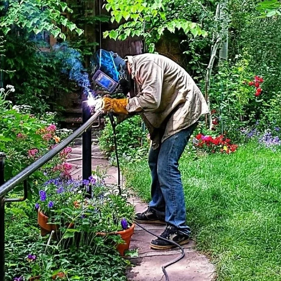 Install of metal railing outside with greenery and flowers