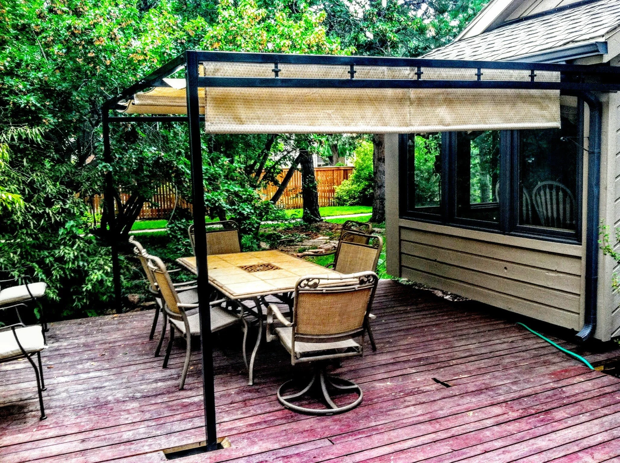 Custom steel pergola structure installed over residential deck patio.