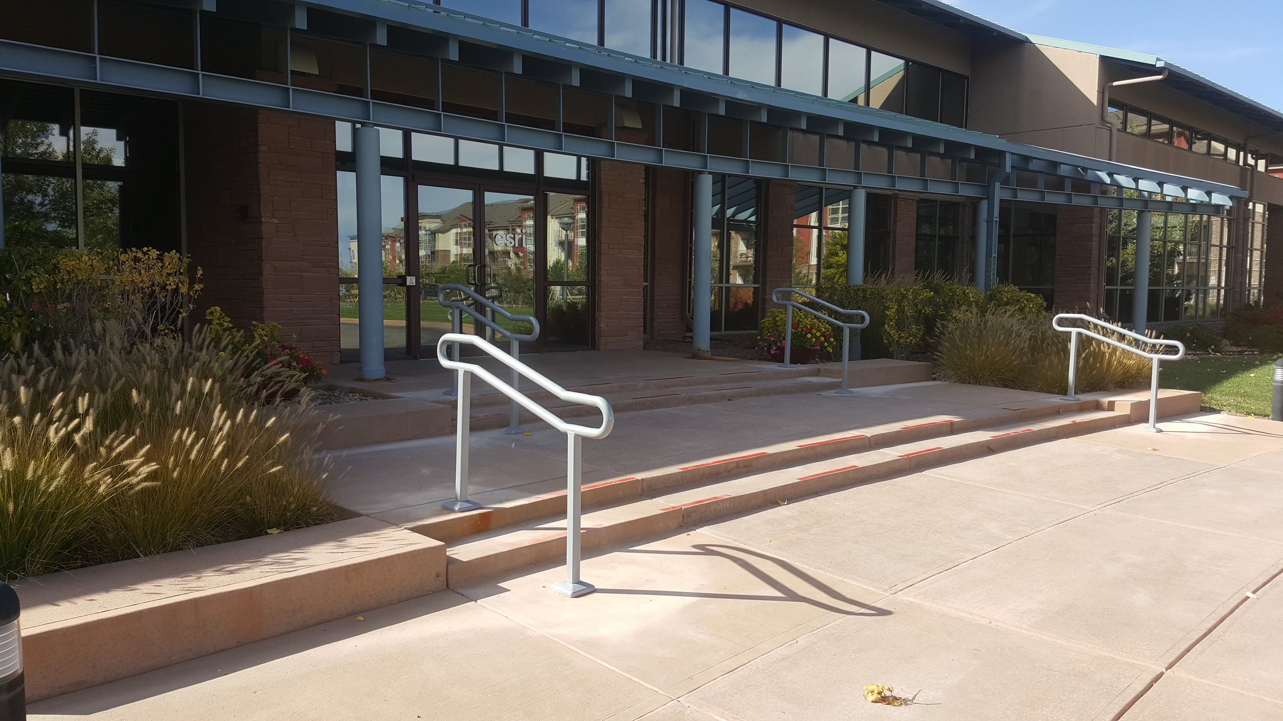 Commercial ADA compliant steel handrails installed at building entrance in Denver Colorado