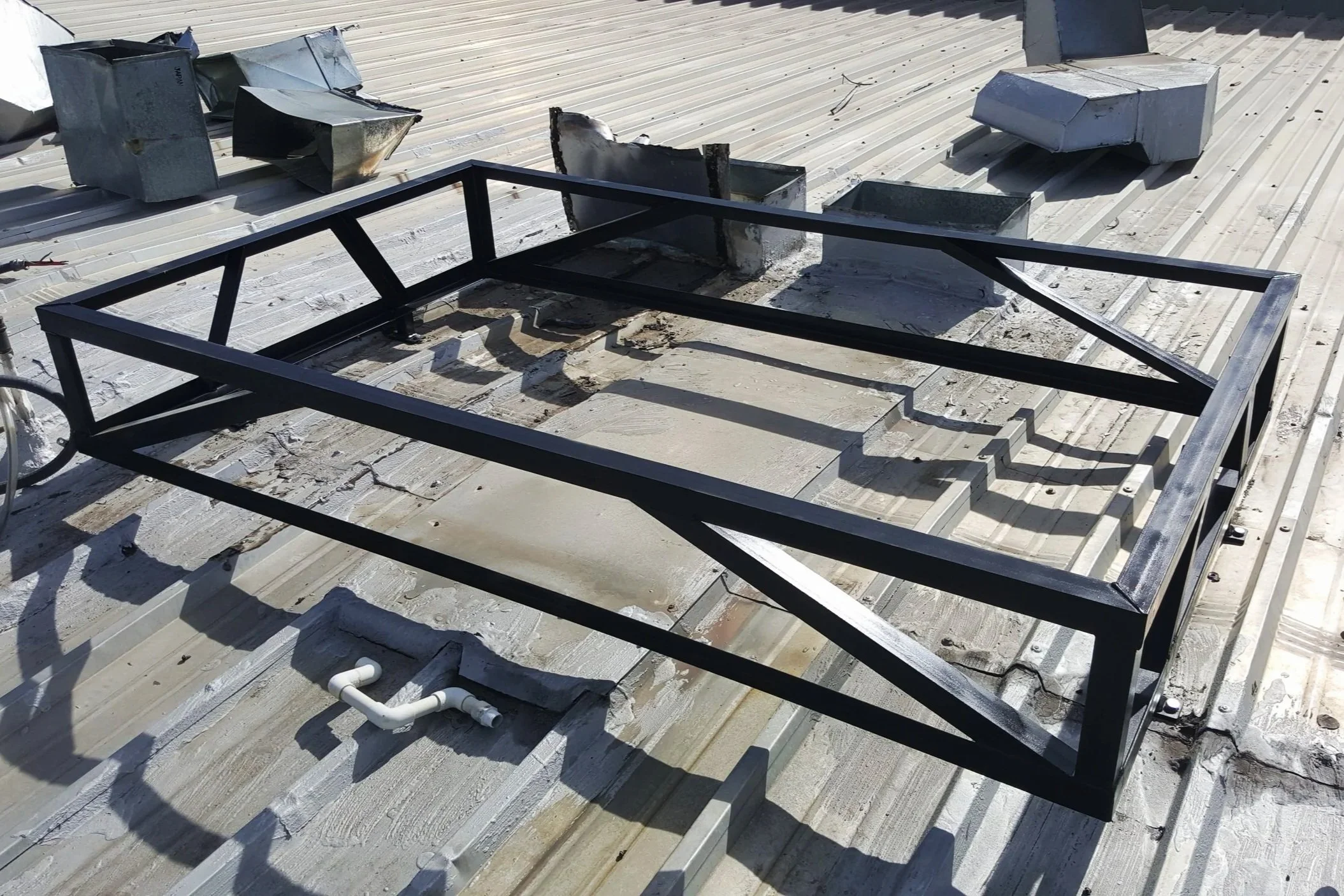 Custom welded steel platform frame installed on commercial metal roof