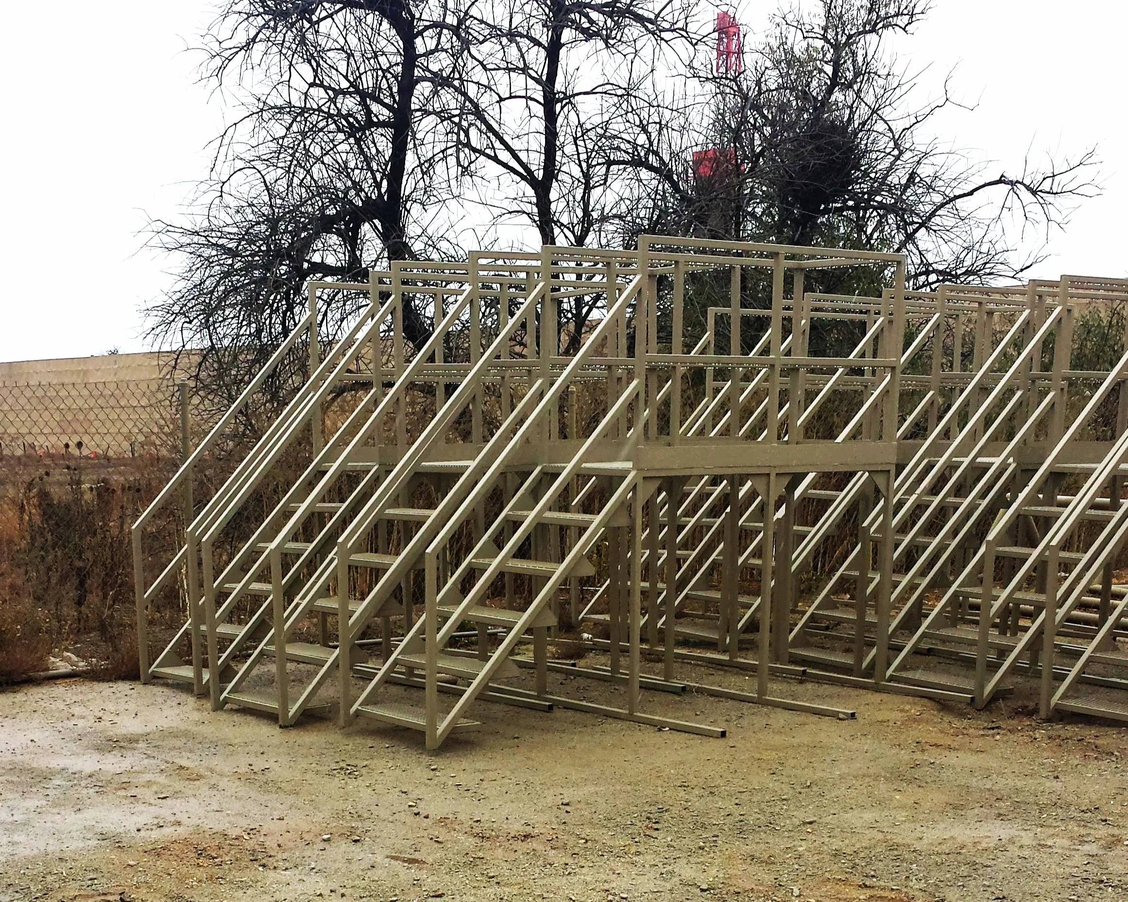 Multiple welded steel industrial stair platforms staged in outdoor yard before installation.