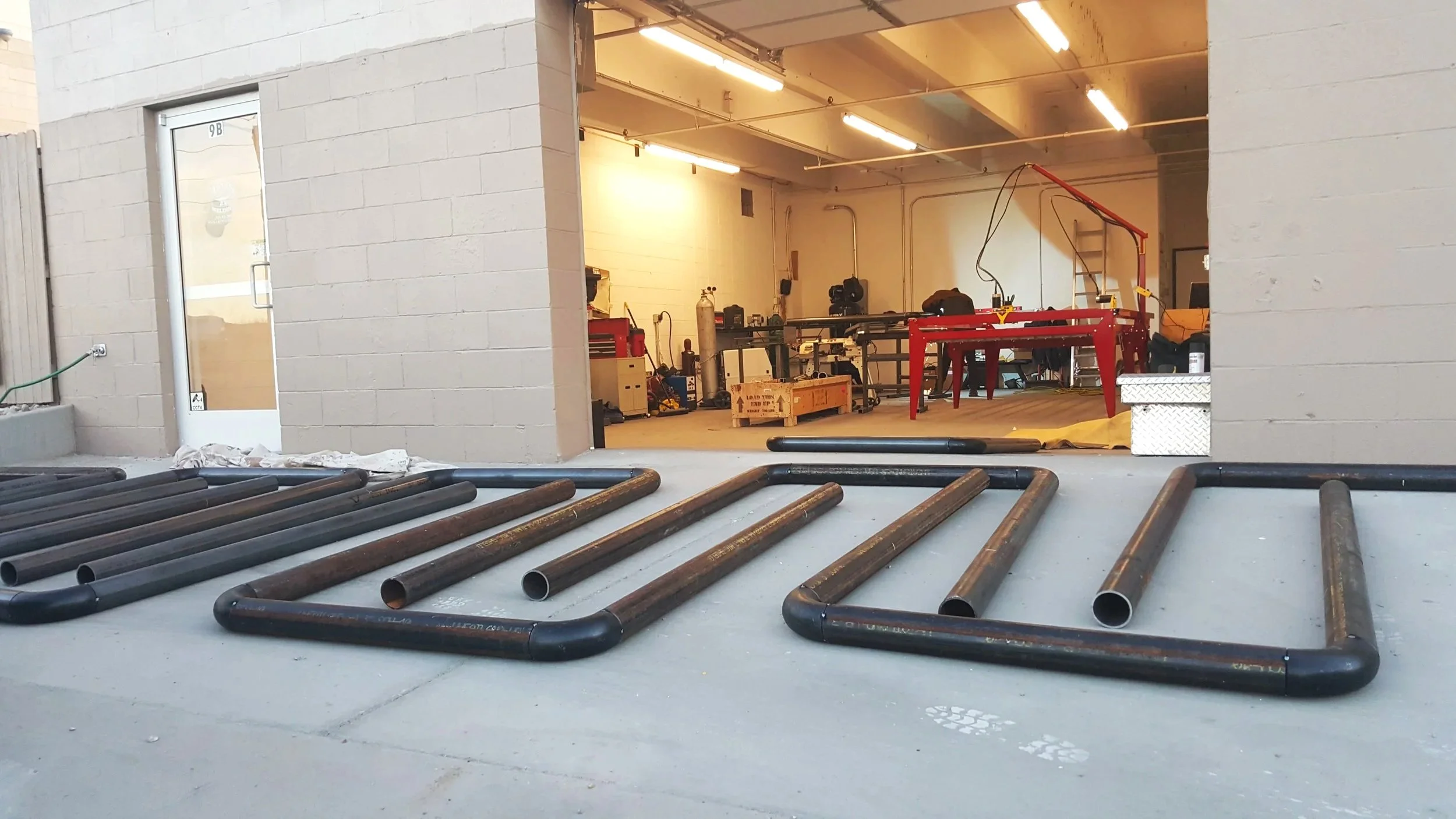 Heavy steel pipe frames laid out on shop floor prior to final welding.