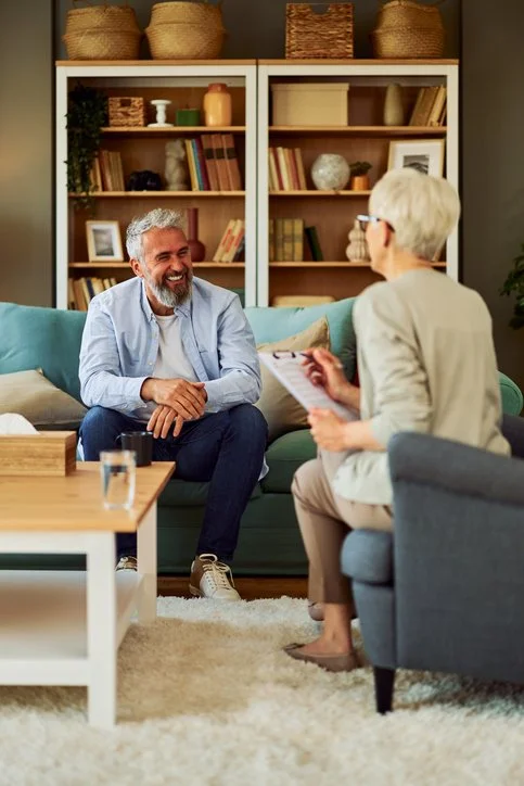 Counselling client connecting with the counsellor, he is smiling and finding value in the session.