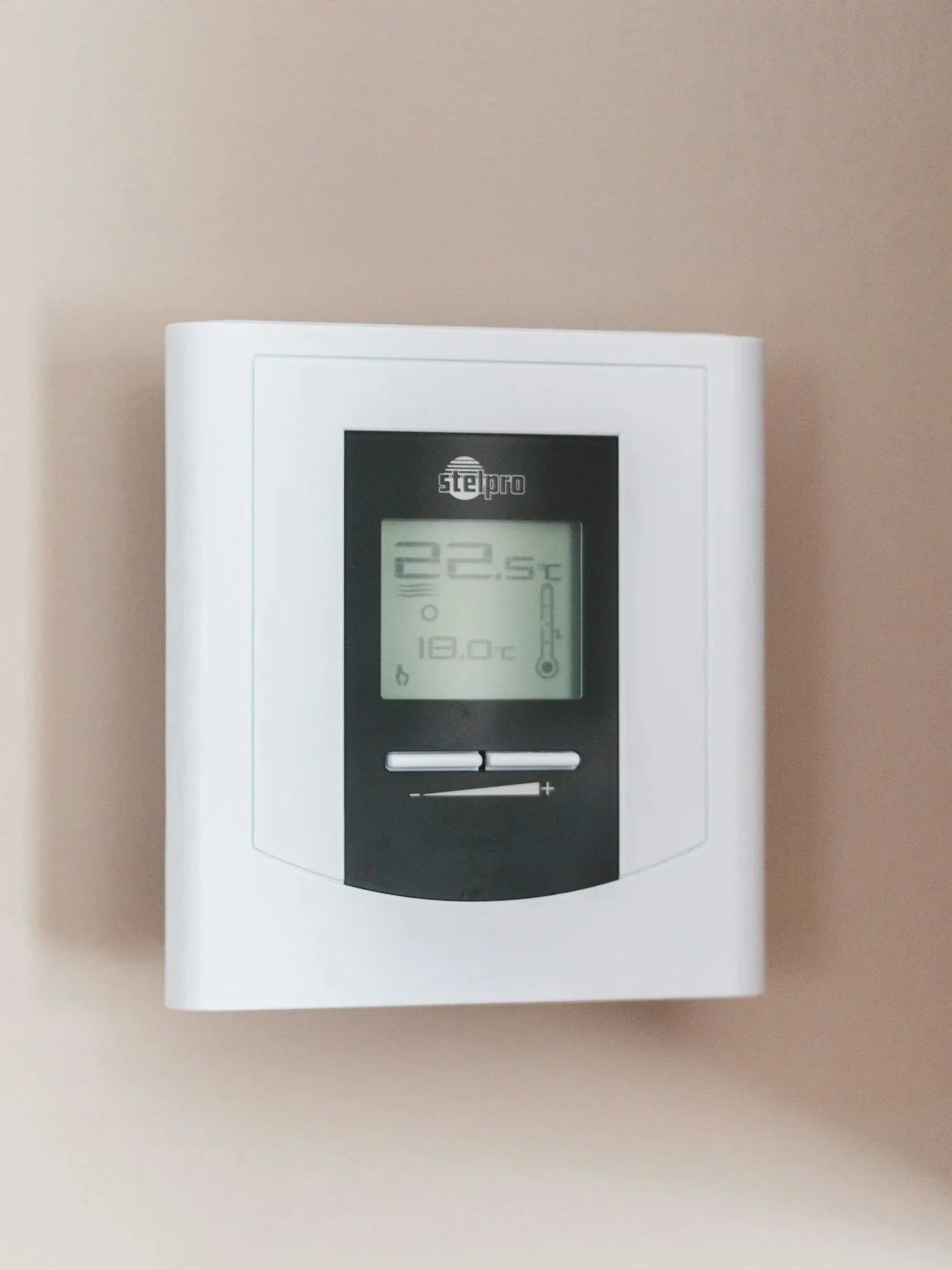 Wall-mounted digital thermostat displaying temperature of 22.5°C.
