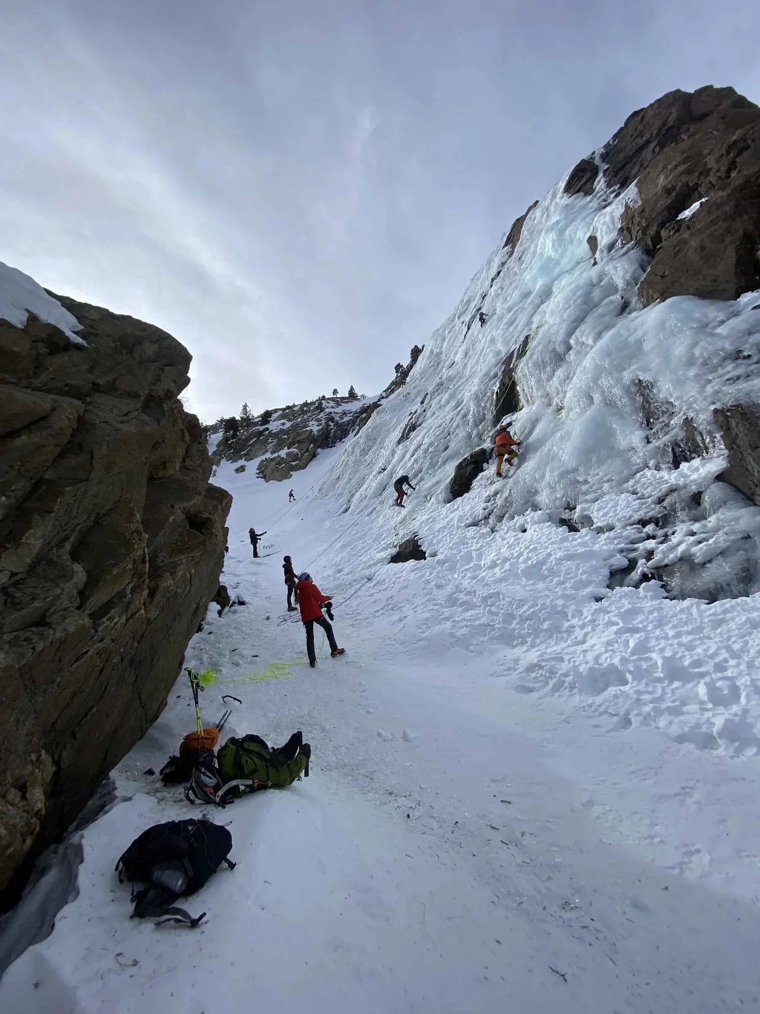 Beginner ice climbing class teaching fundamentals in an outdoor winter setting