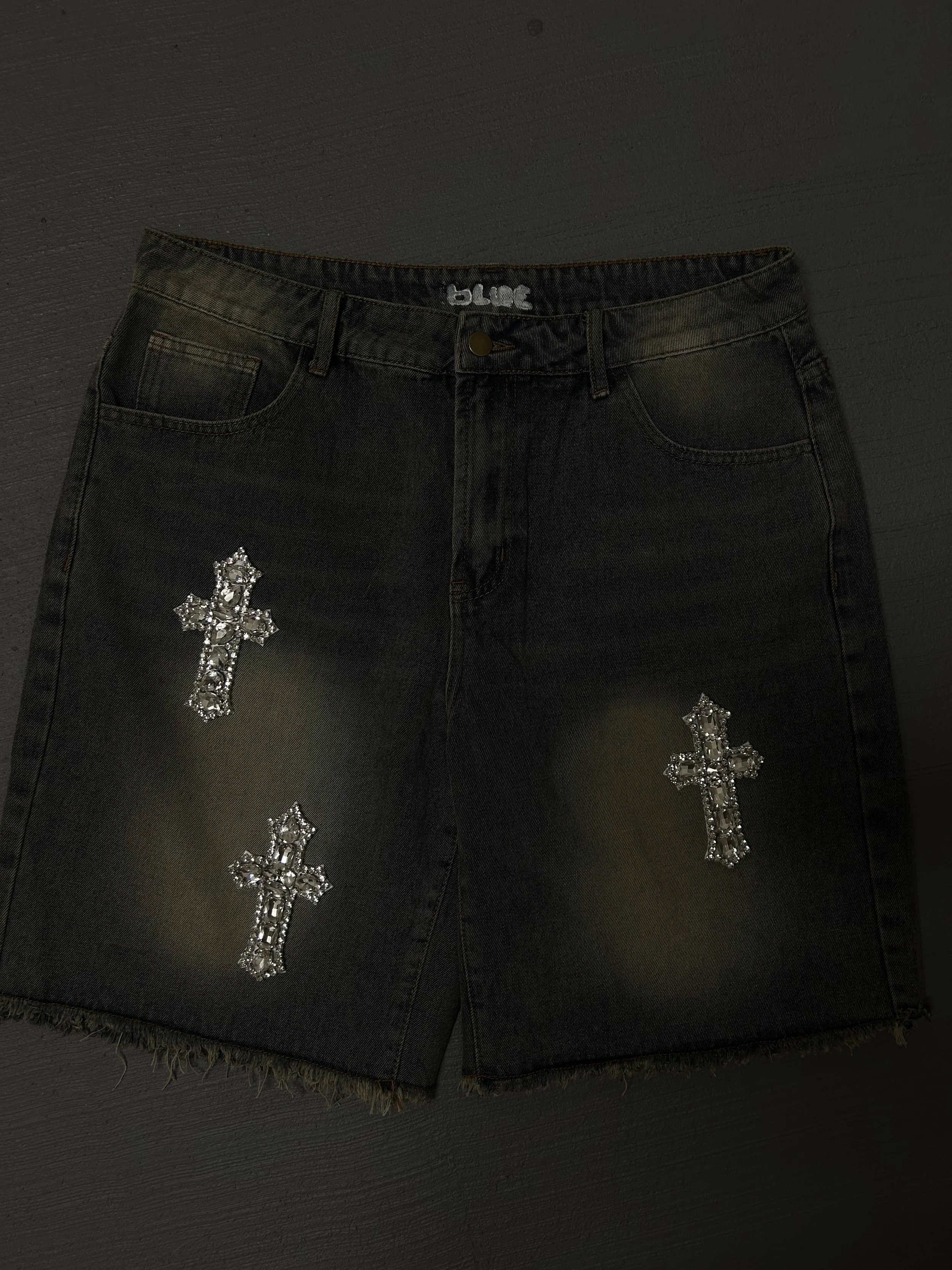 Black denim skirt with three glittery silver cross embellishments.