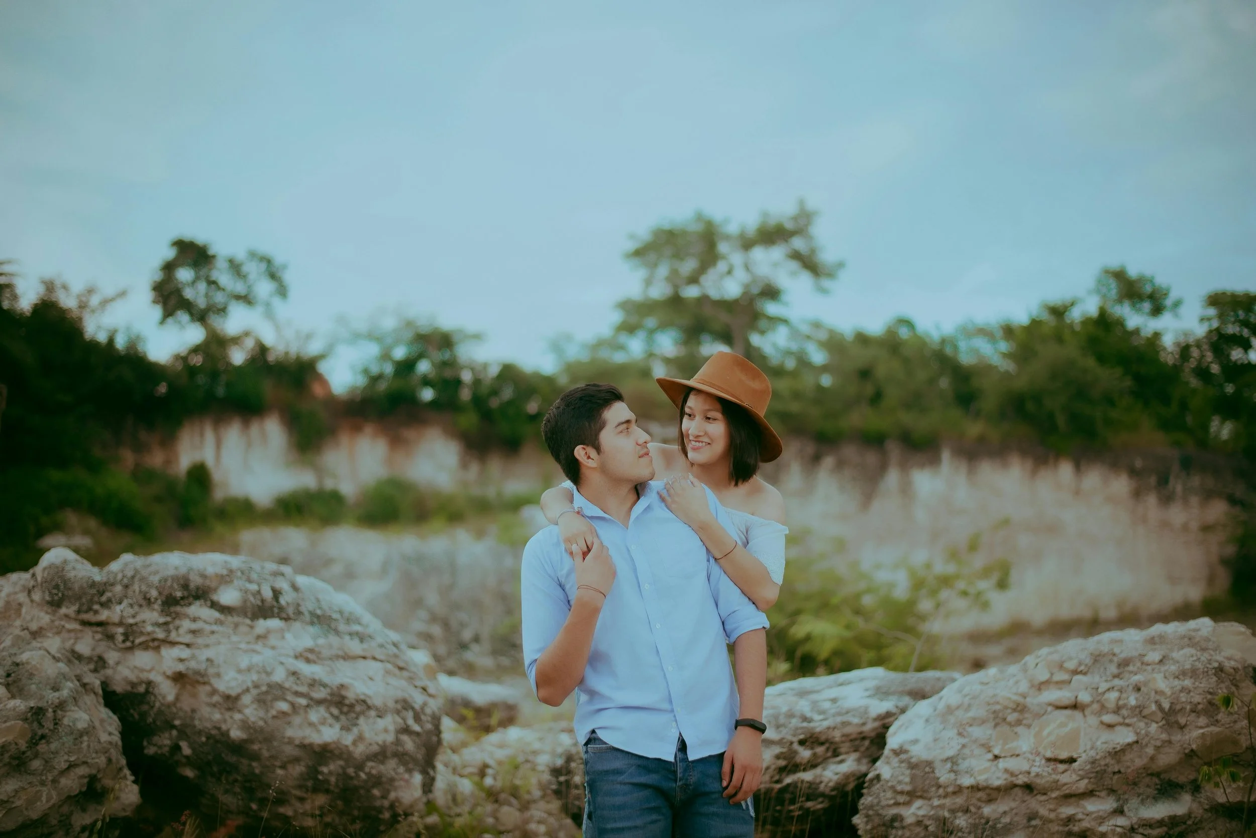 Happy couple outside sitting together on a rock