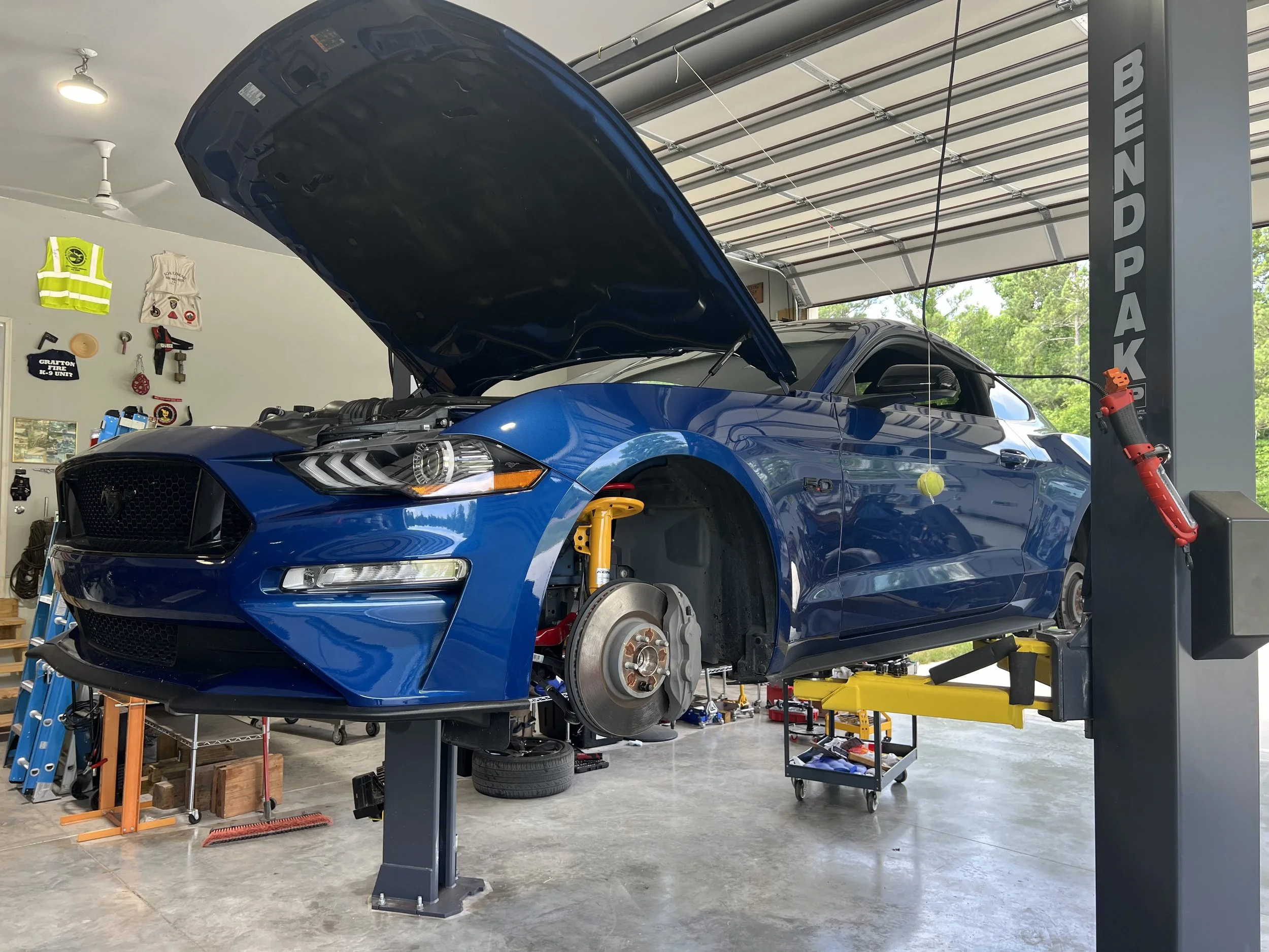 Blue car on lift with hood open