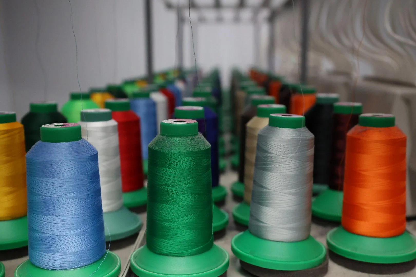 Multiple spools of colorful sewing thread arranged on a sewing machine.