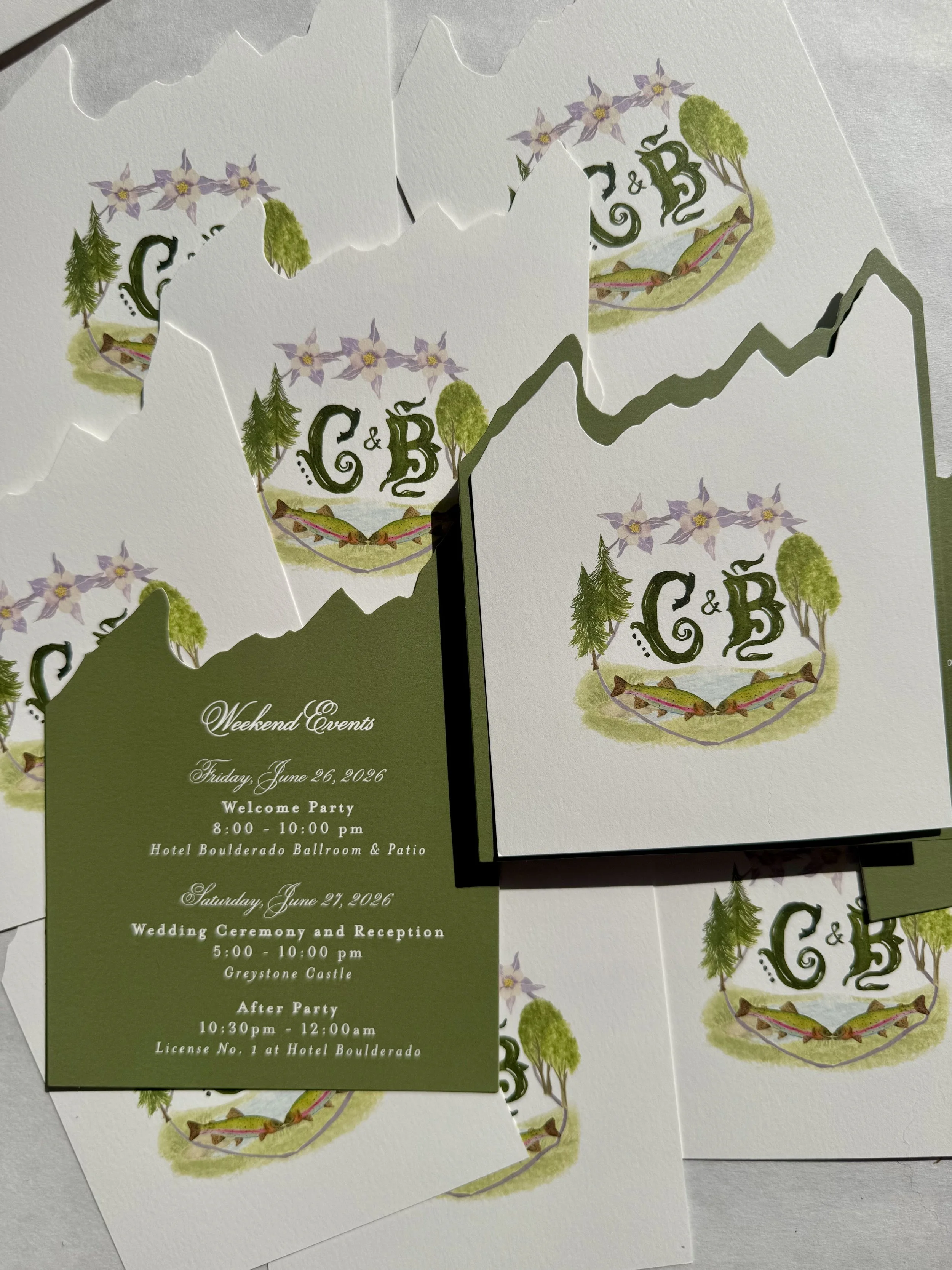 Die-cut watercolor save-the-date featuring the Colorado Flatirons surrounded by colorful wildflowers