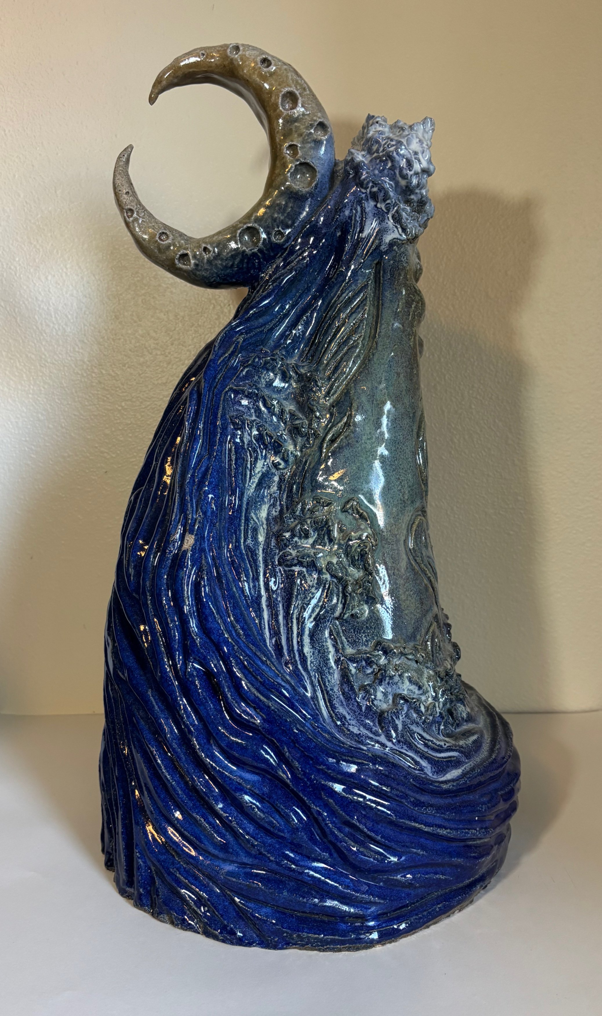 Whale Wave and Waning Moon
2025
Ceramic Stoneware
22 x 12 x 11 in
Coil-built and high-fired at cone 10, this sculpture depicts a whale engulfed by a wave under the watch of a waning moon. The moon controls the tides, and the whale lives in the ocean,