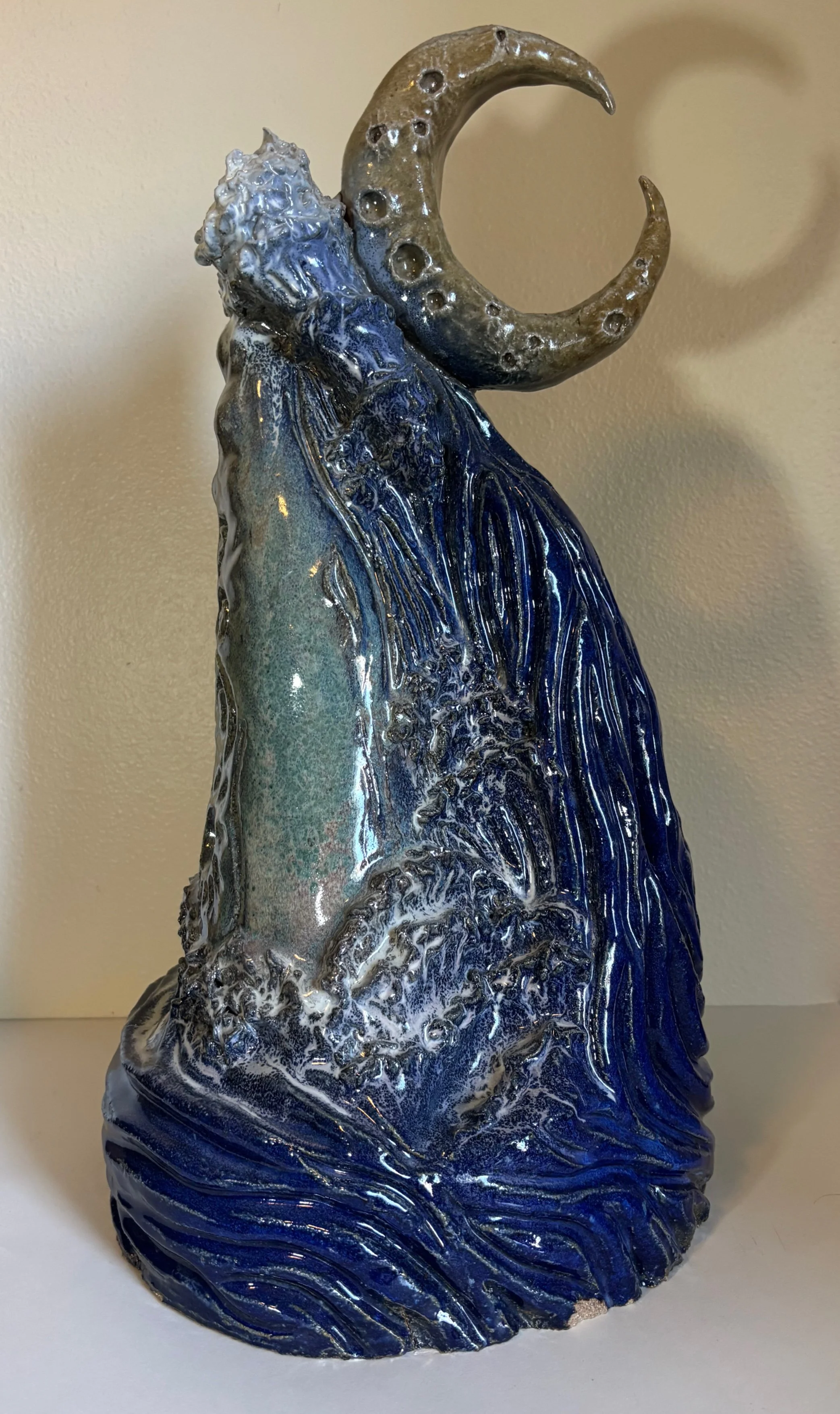 Whale Wave and Waning Moon
2025
Ceramic Stoneware
22 x 12 x 11 in
Coil-built and high-fired at cone 10, this sculpture depicts a whale engulfed by a wave under the watch of a waning moon. The moon controls the tides, and the whale lives in the ocean,