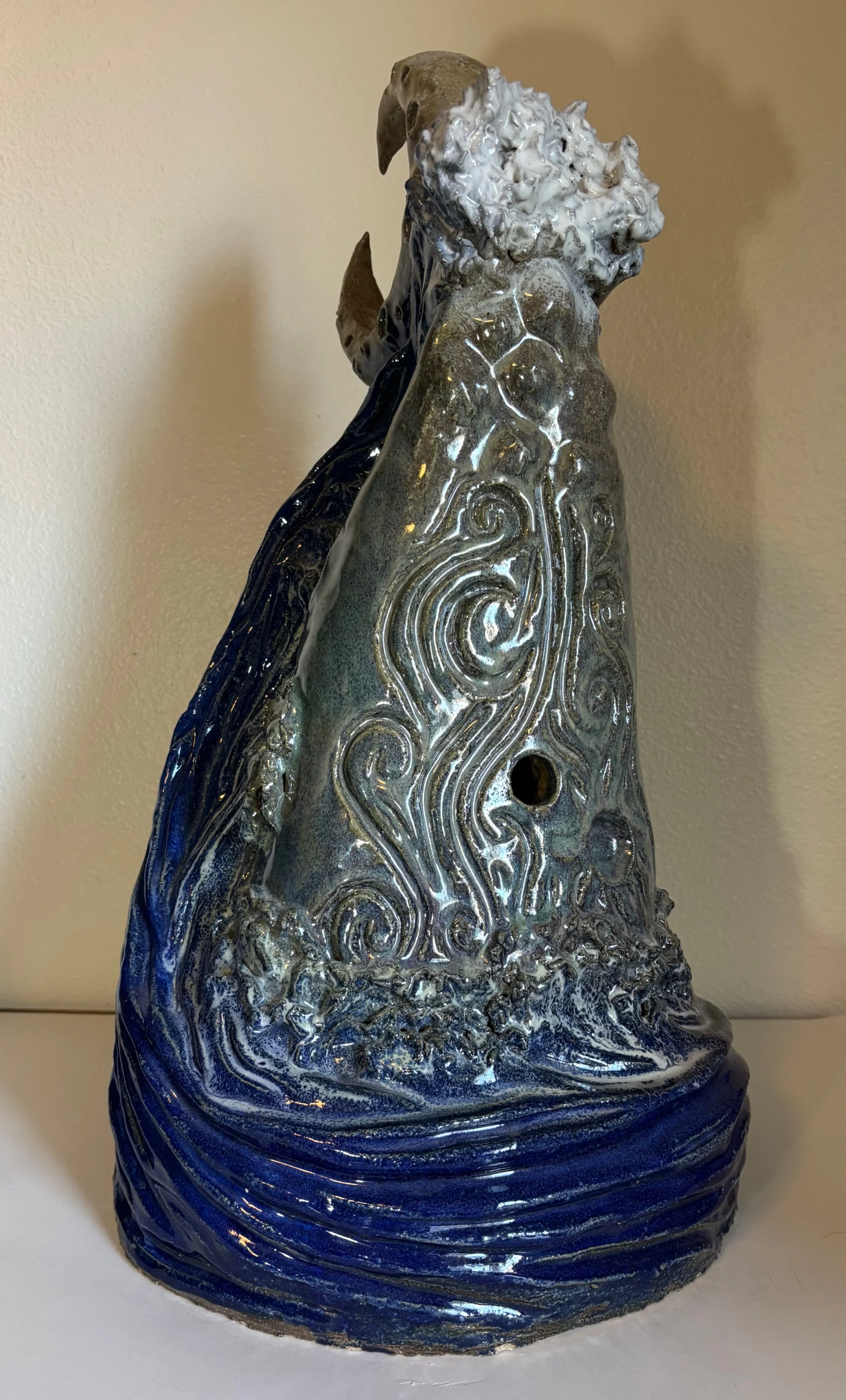 Whale Wave and Waning Moon
2025
Ceramic Stoneware
22 x 12 x 11 in
Coil-built and high-fired at cone 10, this sculpture depicts a whale engulfed by a wave under the watch of a waning moon. The moon controls the tides, and the whale lives in the ocean,