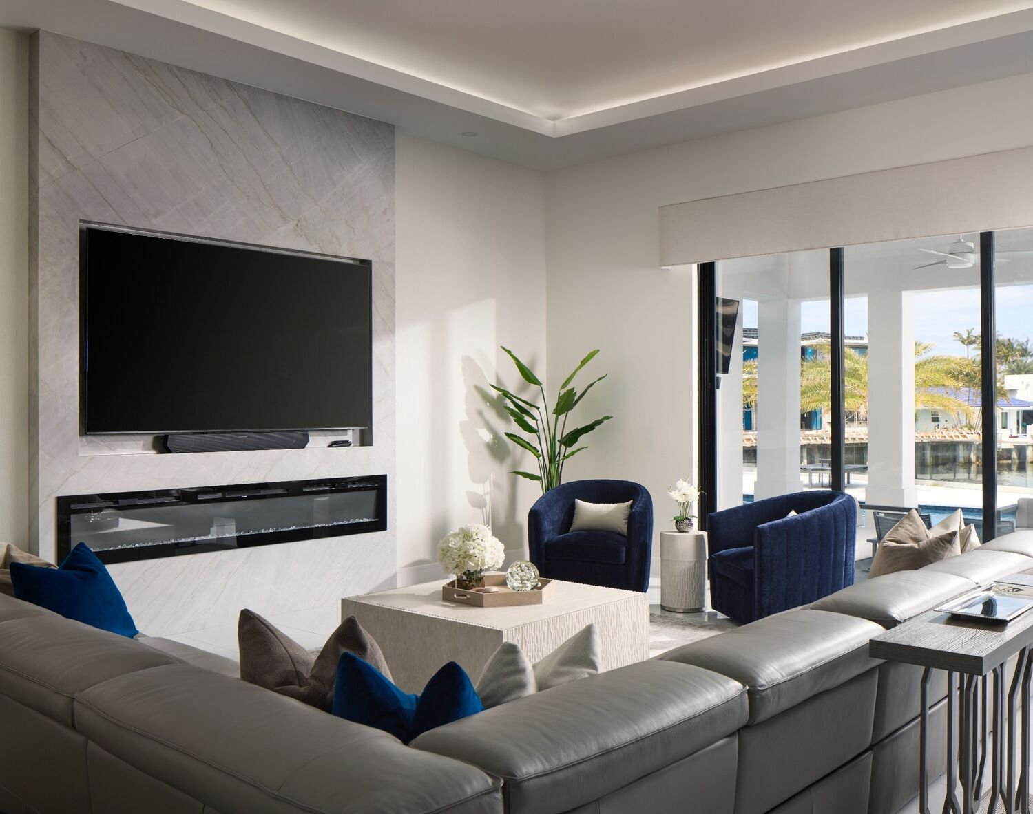 Boca Raton living room with gray sectional sofa, layered lighting, and coastal modern finishes