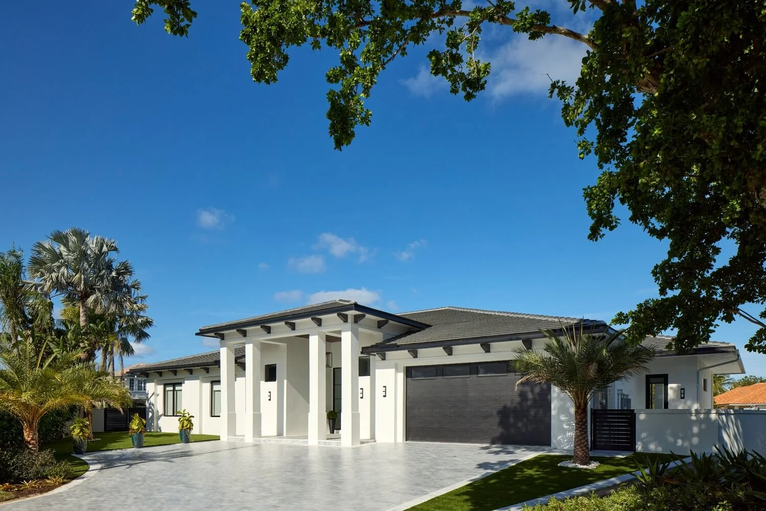 South Florida modern home exterior with white architecture, clean-lined columns, and palm landscaping