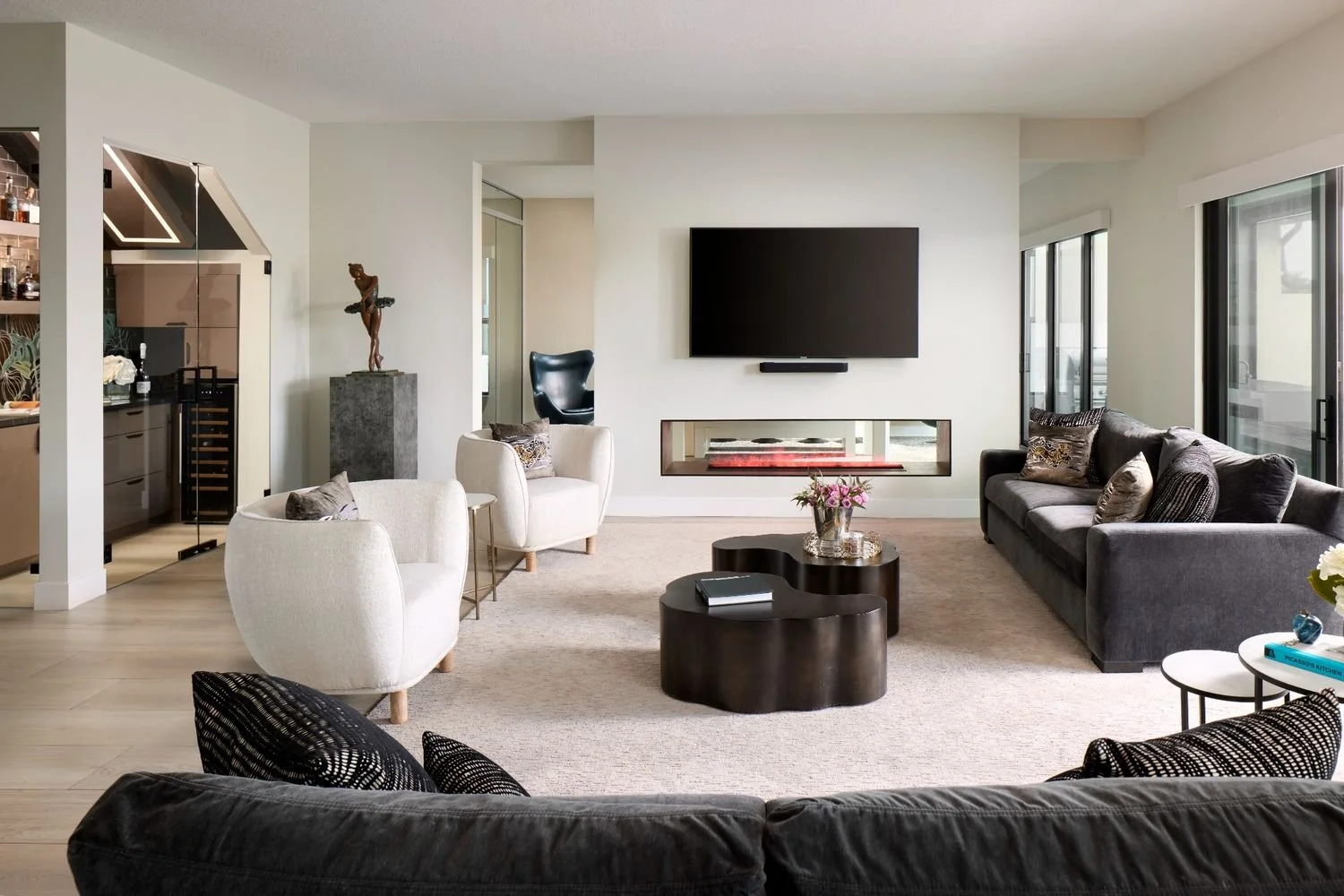 Modern living room design with wall-mounted TV, linear fireplace, neutral seating, and contemporary coffee table