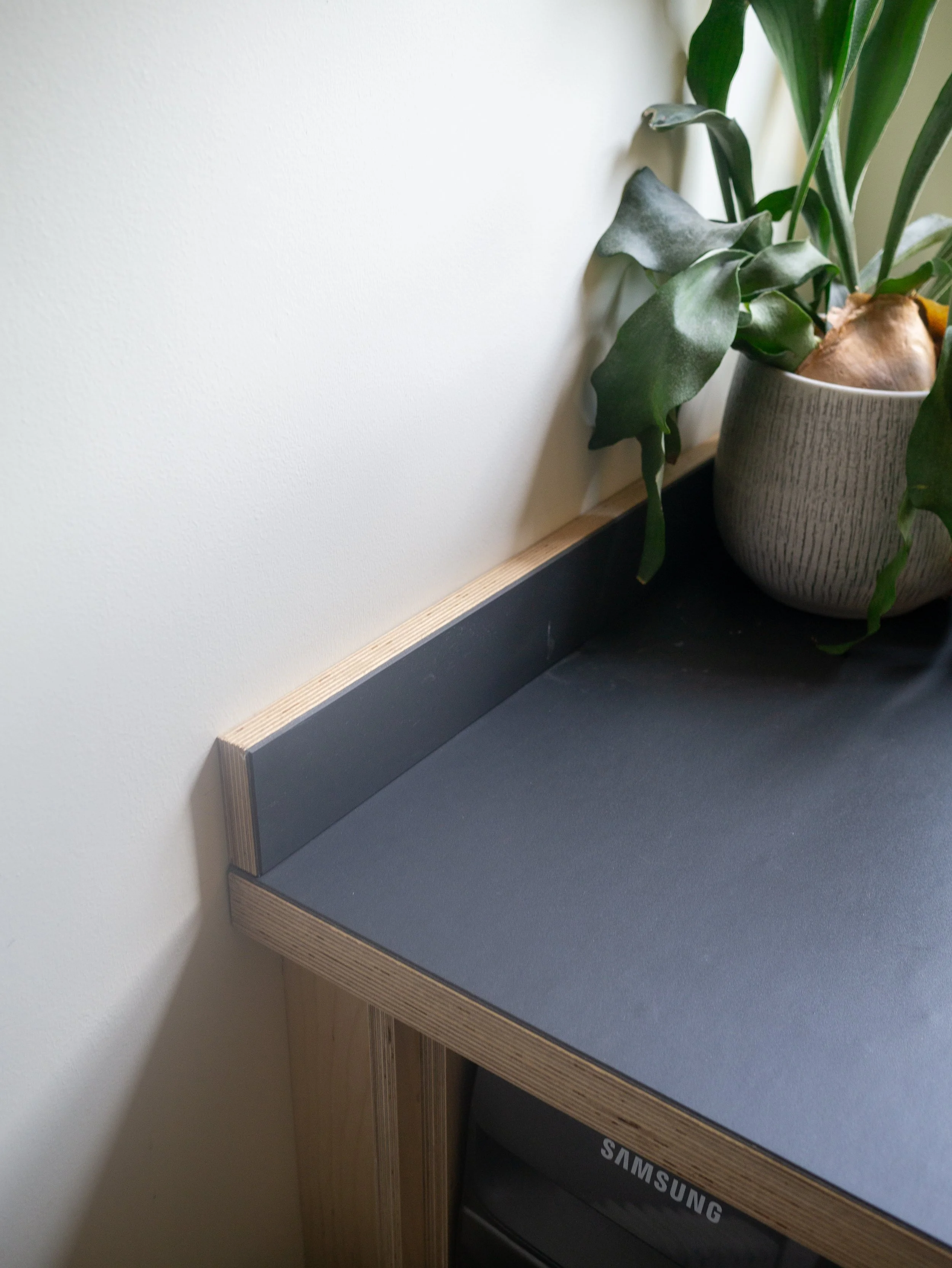 Bespoke utility cabinetry in birch plywood with counter tops finished in Forbo furniture grade Lino. 'J' groove handles