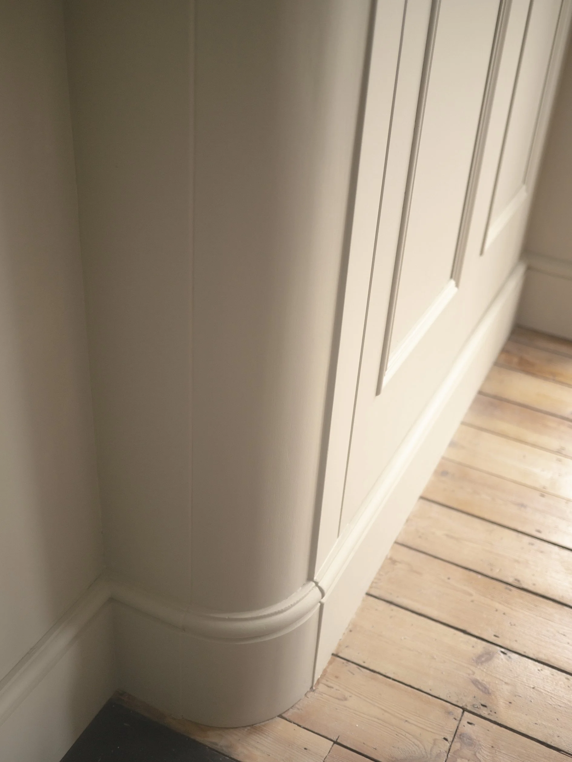 Curved corner detail of a Victorian Georgian bespoke fitted wardrobes. Corston hardware and Farrow & Ball dead flat paint finish
