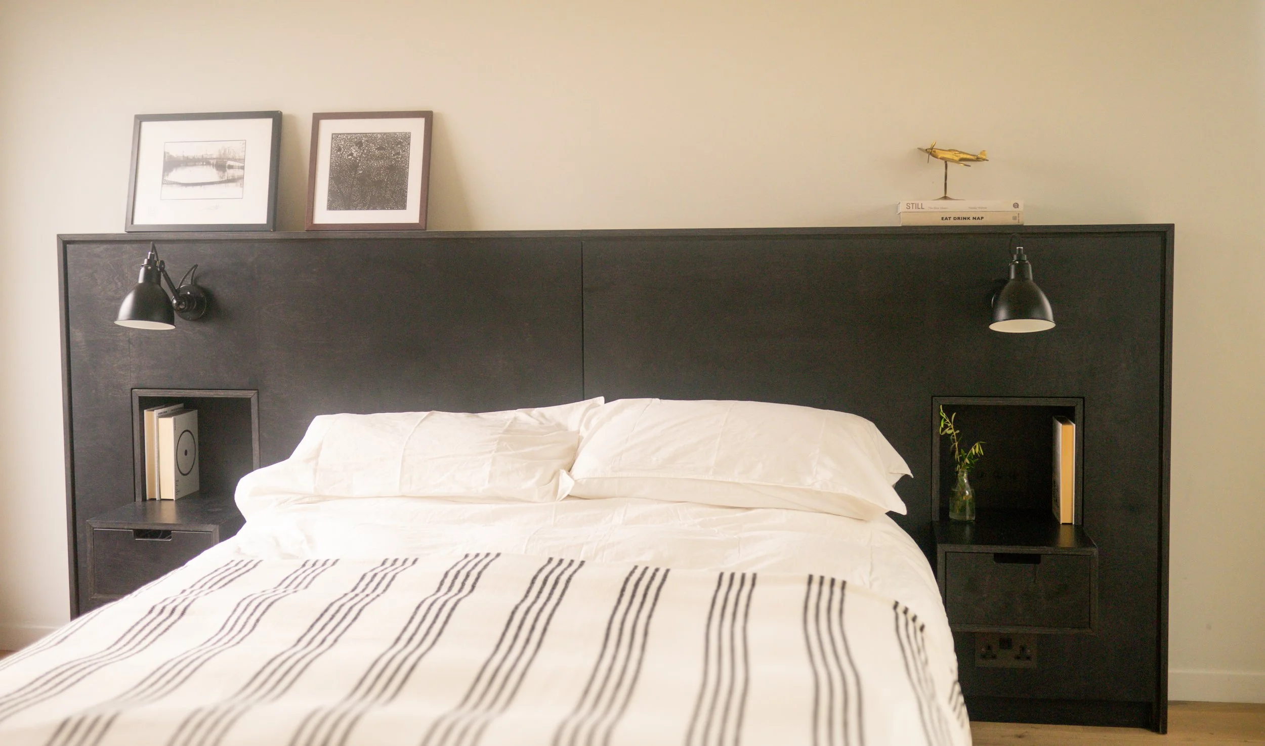 Bespoke bedhead head board in dark stained birch plywood with floating beside cabinets and integrated lighting and swithes