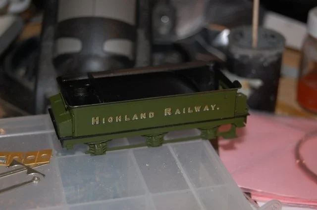 A small green model train car with