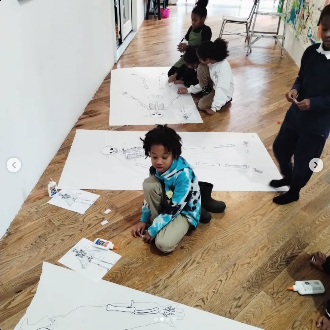 Children working on educational posters about the human skeleton, coloring and learning anatomy at school.