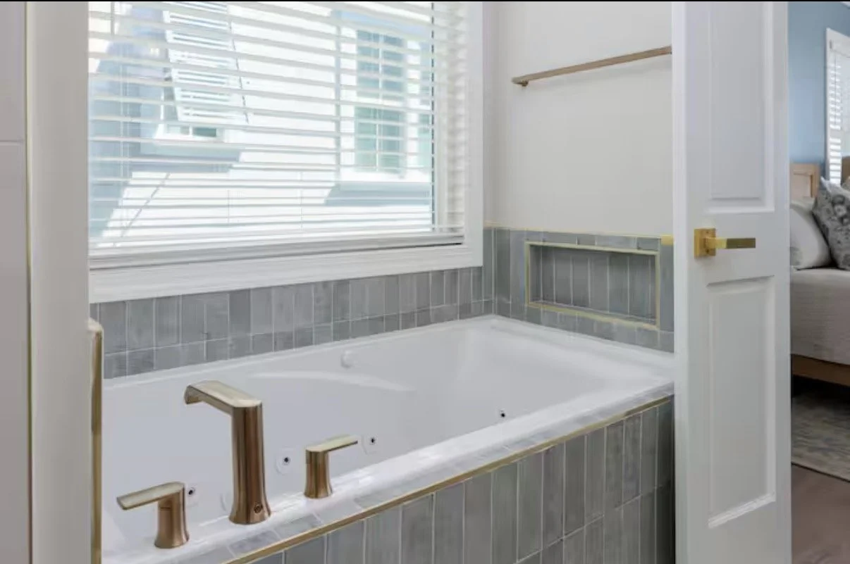 For this coastal vacation rental in Kure Beach, Foxglove & Fir Design Studio curated the bathroom finishes, selecting cabinetry, countertops, tile, plumbing fixtures, and hardware to create a cohesive and timeless design.