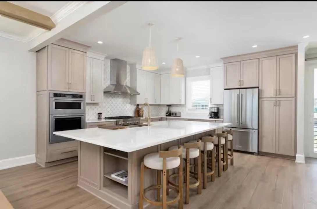For this coastal vacation rental in Kure Beach, Foxglove & Fir Design Studio selected the kitchen finishes, including cabinet color and style, backsplash, countertops, and hardware to create a cohesive, elevated, and timeless design.