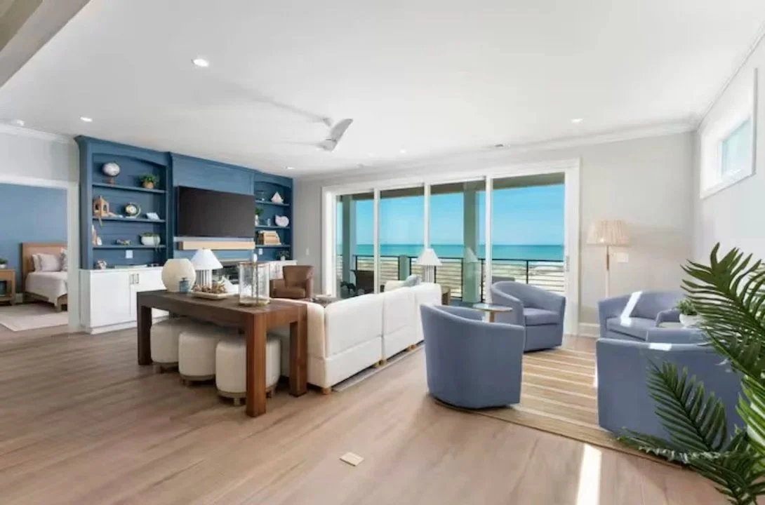 Designed for gathering and relaxation, this luxury vacation rental in Kure Beach features an open-concept living area with custom built-ins, coastal-inspired tones, and panoramic ocean views for an elevated guest experience. Designed by Foxglove and 
