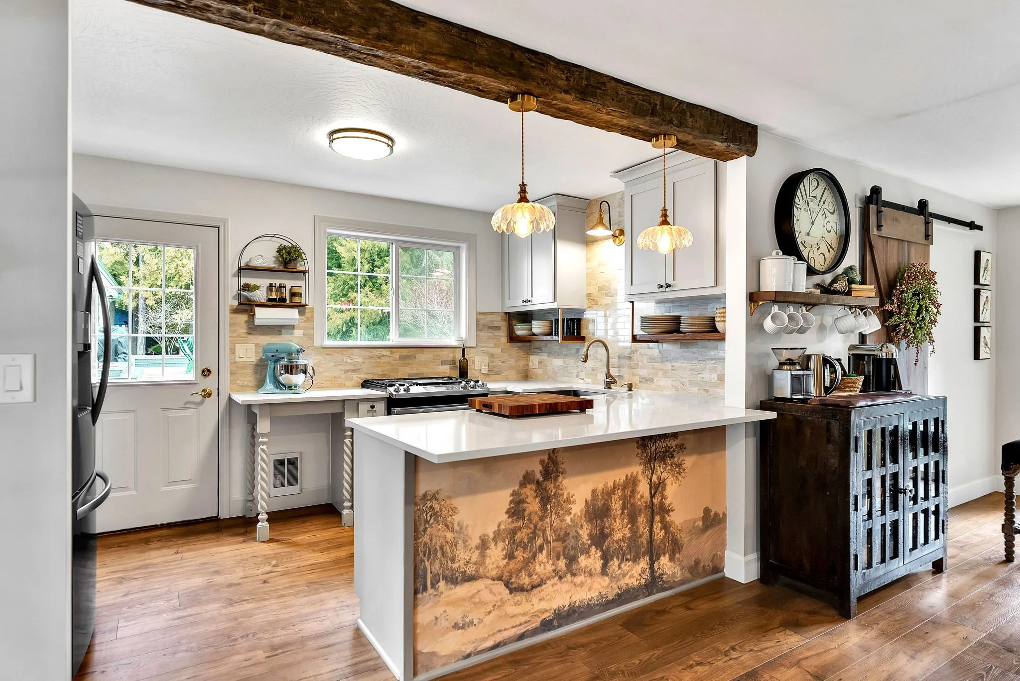 Warm cottage kitchen renovation in Bayview Idaho featuring custom cabinetry, quartz island, brass lighting, and layered vintage details.