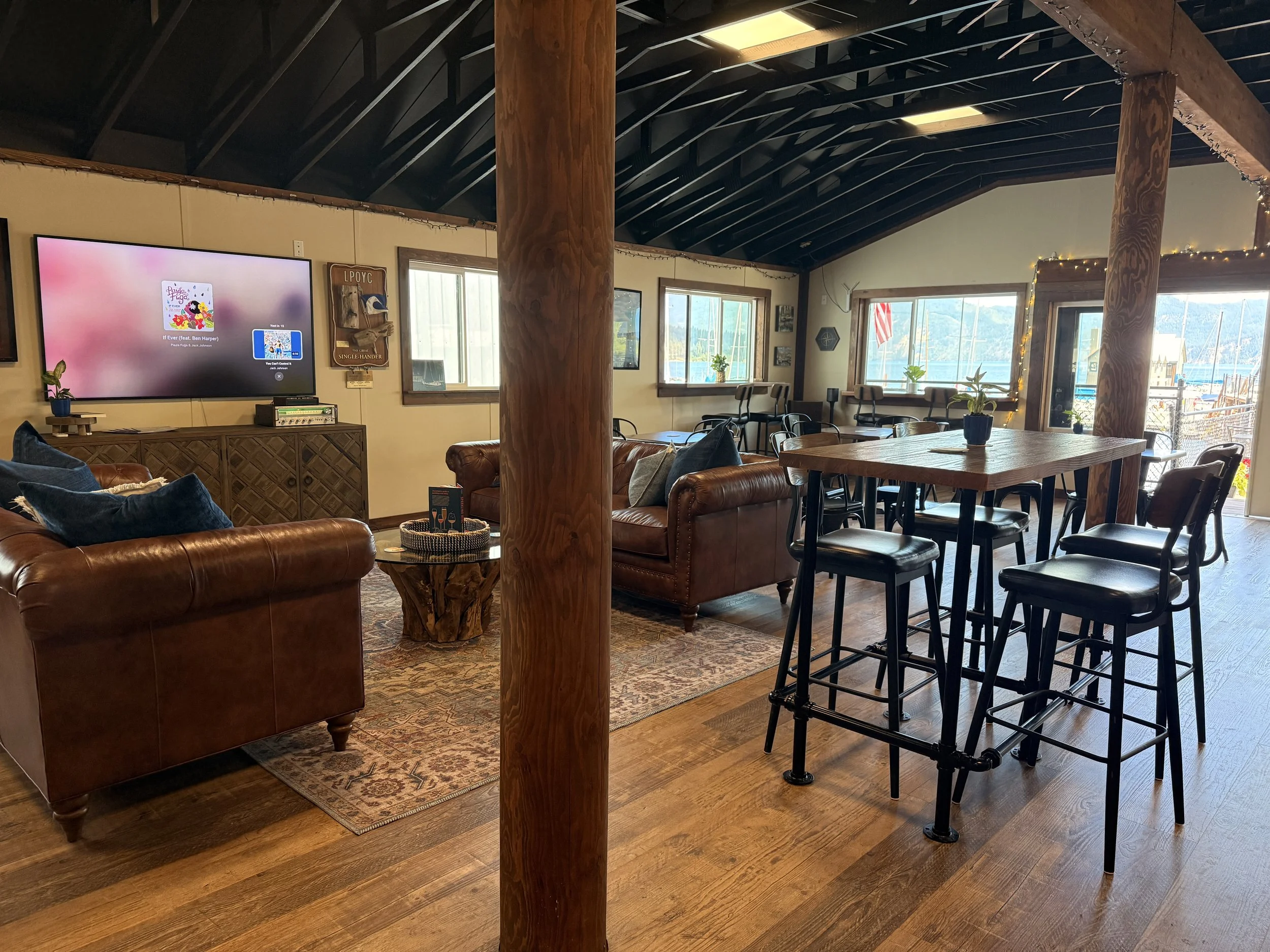 Custom café lounge design featuring vintage leather sofas, layered rugs, and rustic commercial styling in Bayview Idaho.