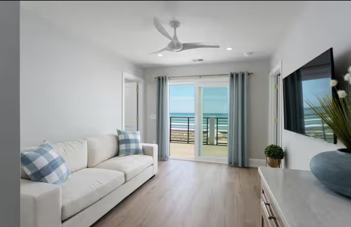 Interior selections for this Kure Beach vacation home focus on light-filled spaces, warm wood flooring, soft coastal textiles, and timeless finishes that bring comfort and function to seaside living.
