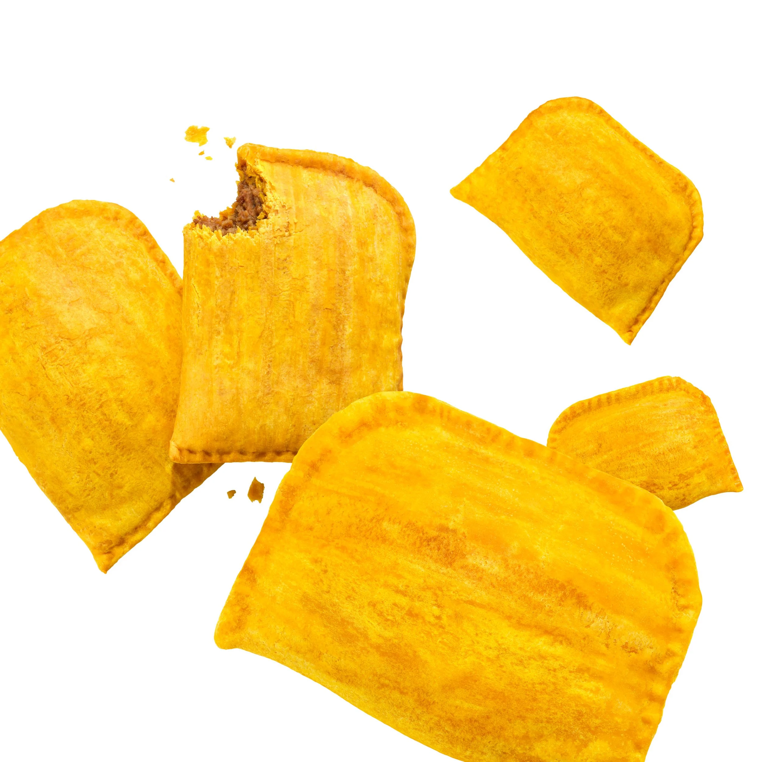 A number of Jamaican patties with one having a bite taken out of it.