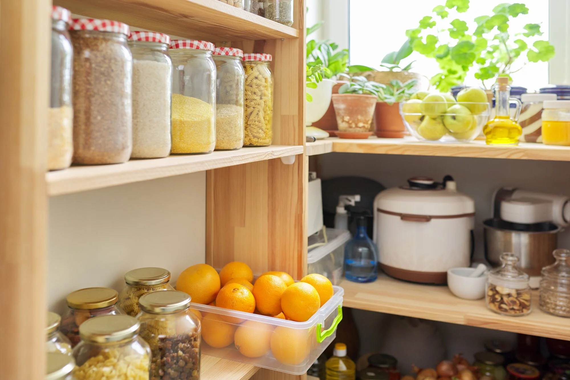Organized kitchen pantry with wooden shelves and storage jars