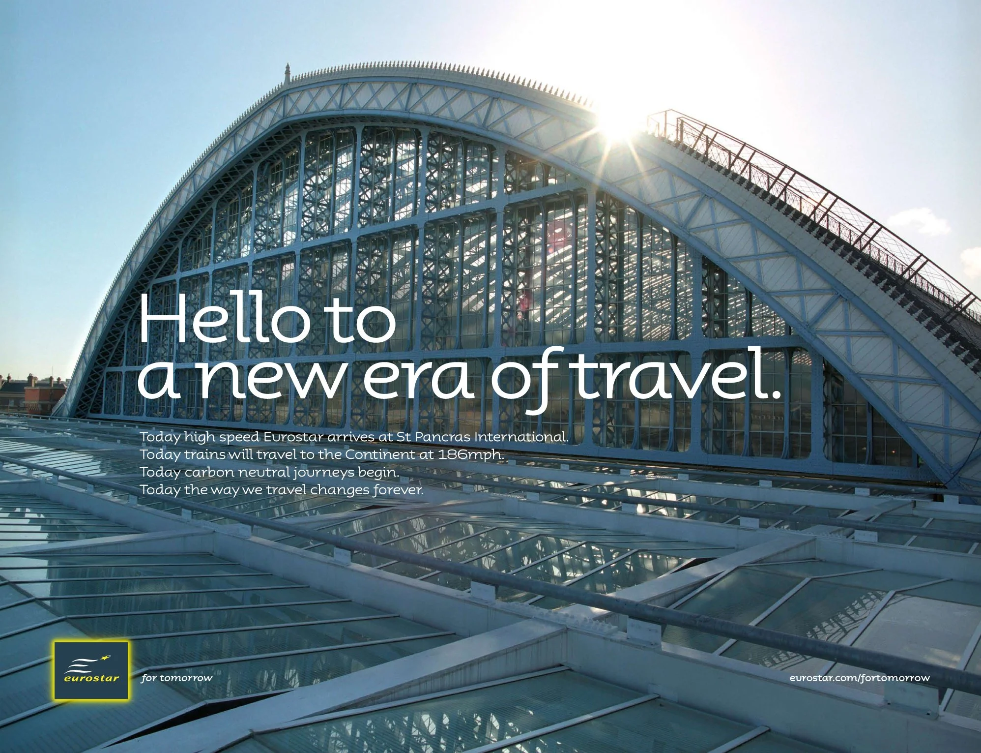 Front of a modern glass and steel building with a large arch, sunlight shining through, and promotional text overlay about Eurostar's new travel era at St Pancras International.