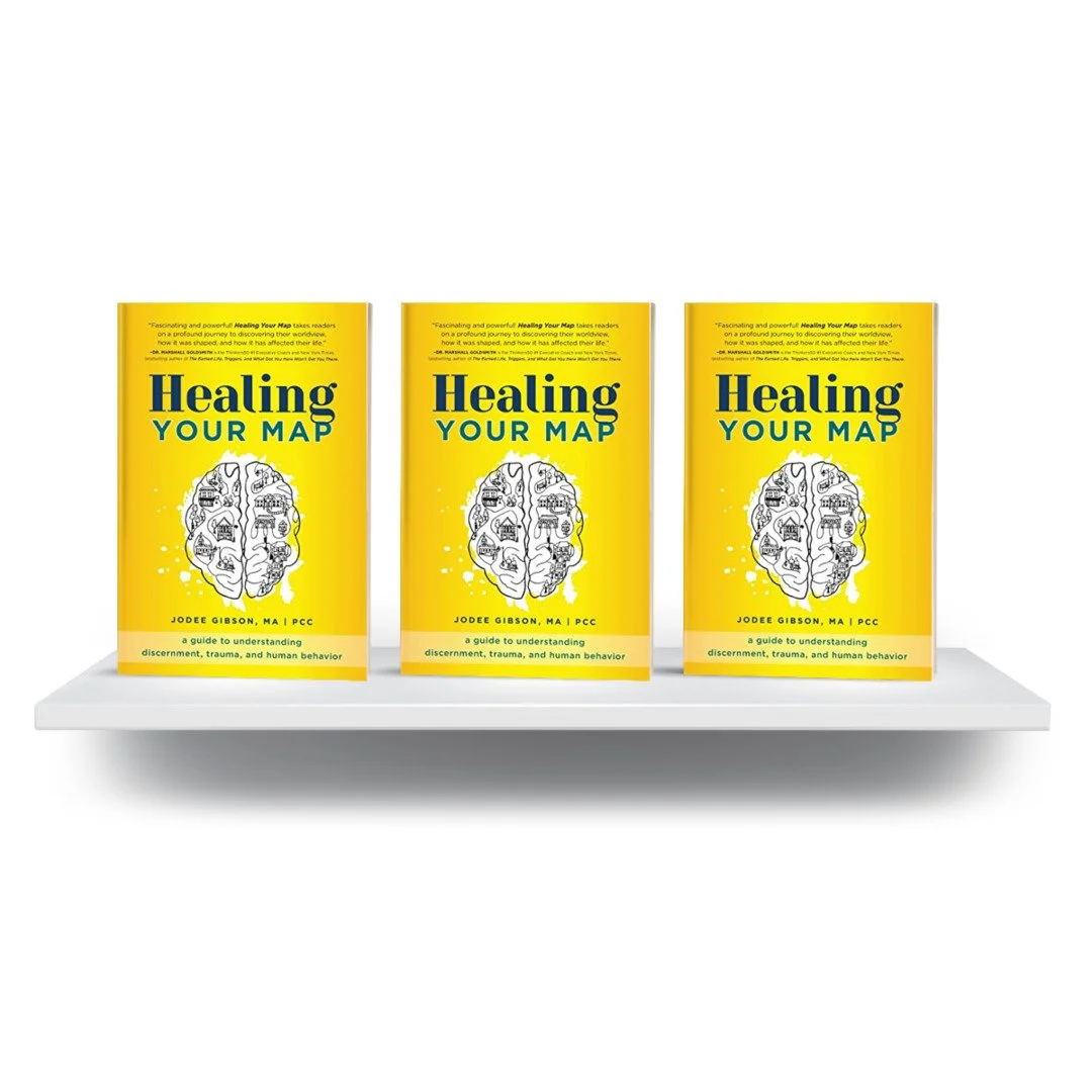 Three copies of a book titled 'Healing Your Map' displayed on a white shelf.