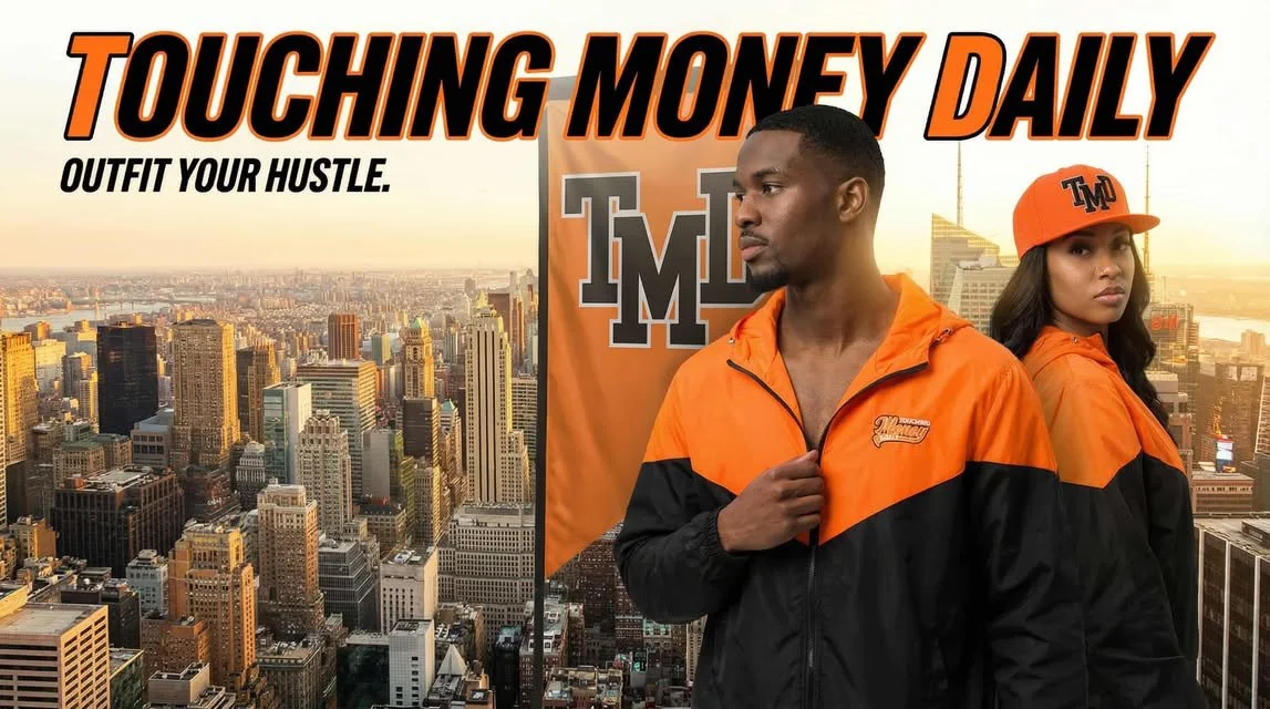 Two young adults in orange and black jackets and caps standing in front of a banner that reads 'Touching Money Daily' with a city skyline sunset in the background.