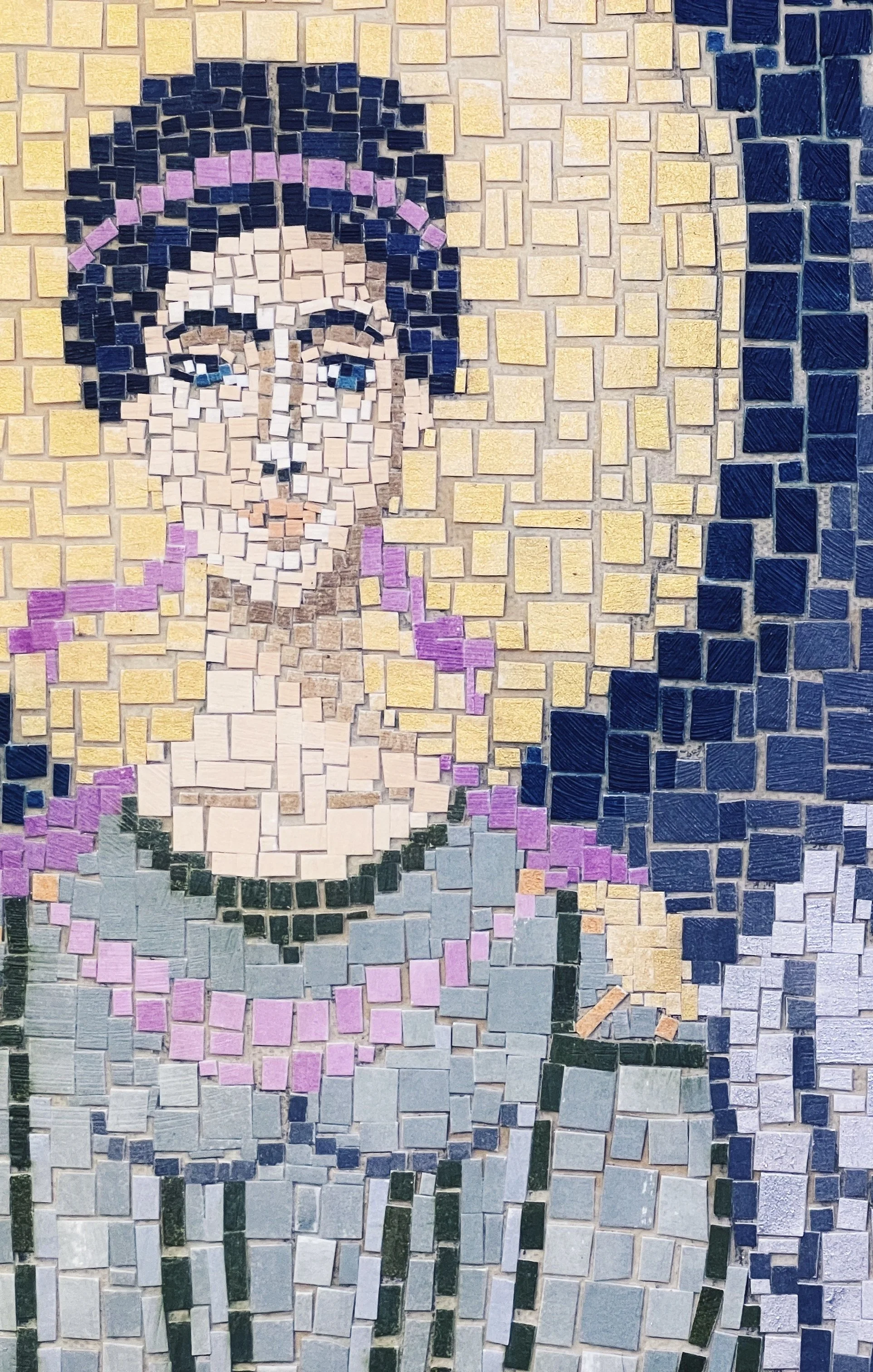 Mosaic style cut paper collage portrait of an angel with dark hair, blue eyes, a purple ribbon and a golden halo