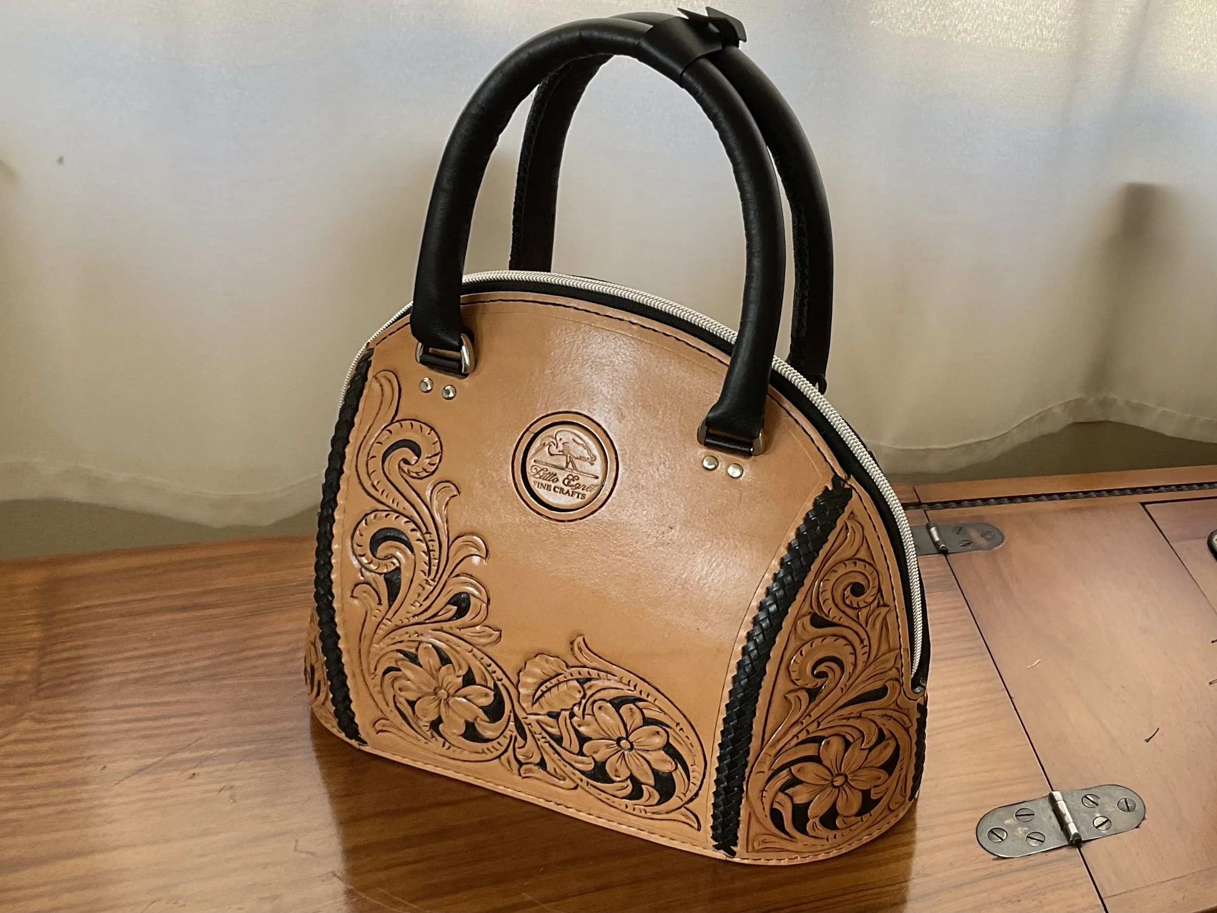 A leather handbag to last a lifetime.  Hand tooled and left natural with lacing highlights and rolled handles