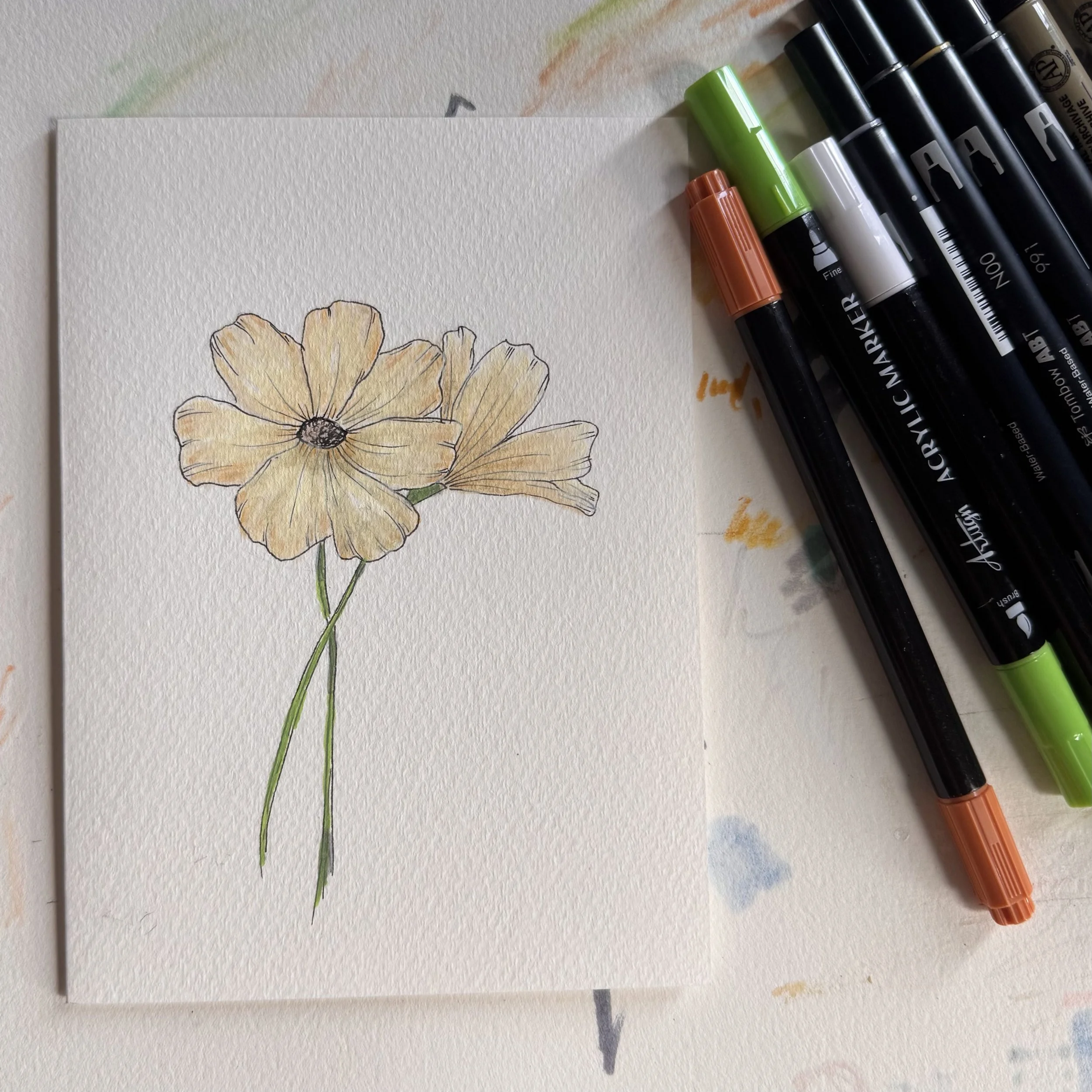 card with two yellow flowers next to a pile or markers