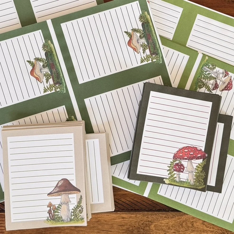 piles of notepads with mushrooms of various colors