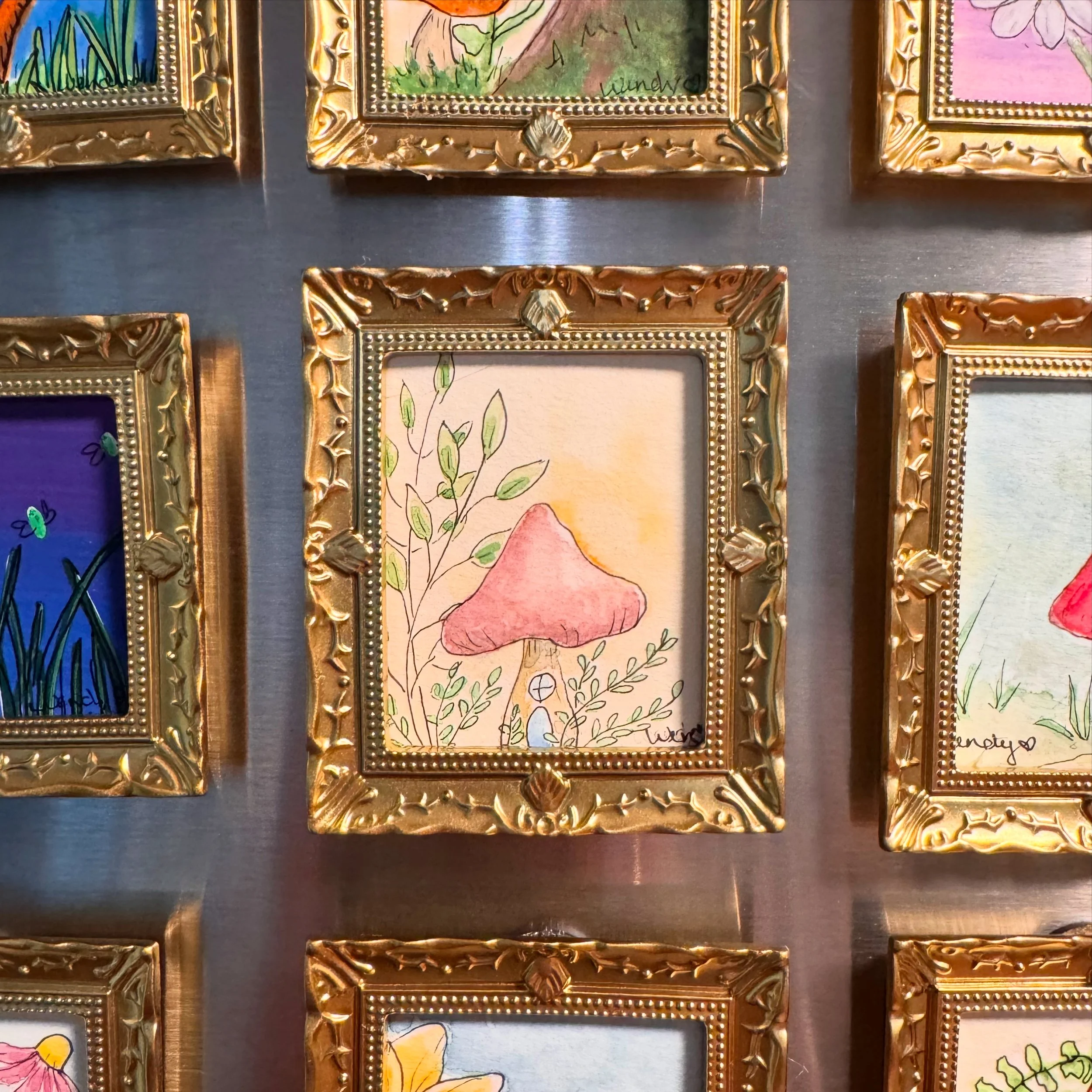 gold frame mini painting stuck on a fridge with magnets