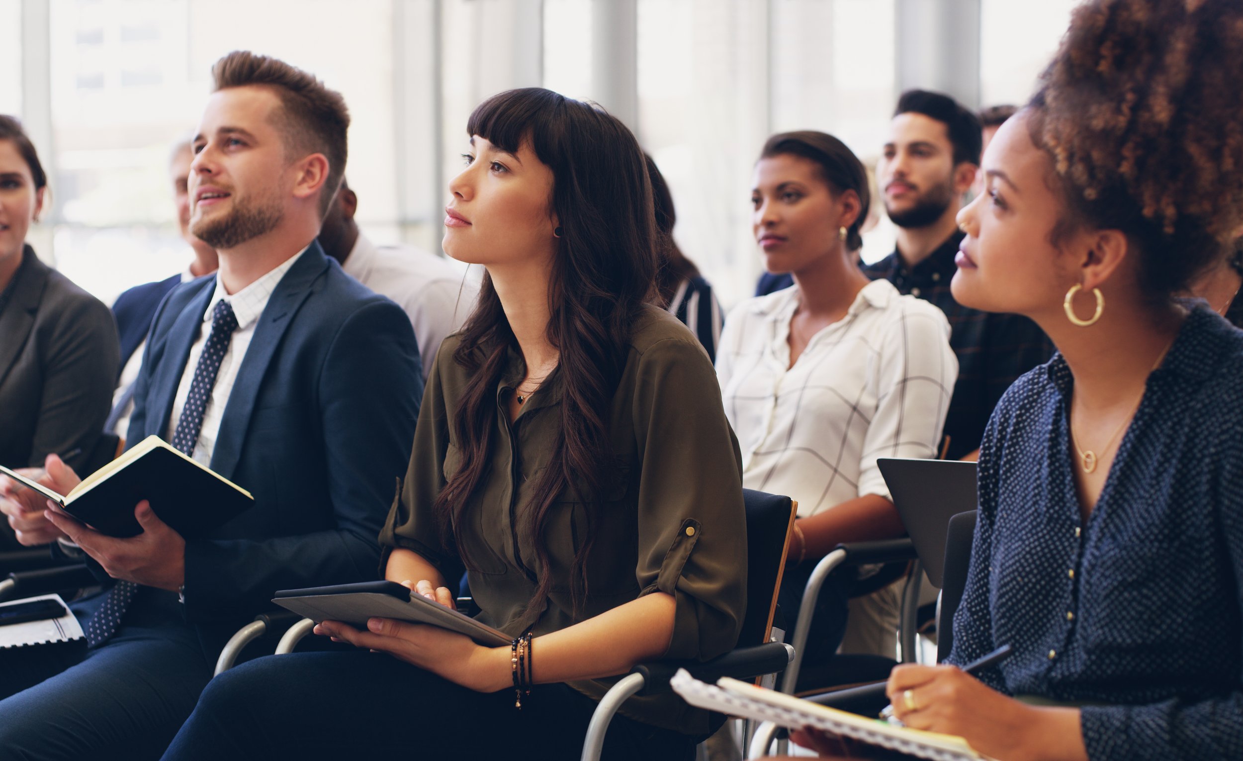Group of diverse business professionals attending a conference, listening attentively.