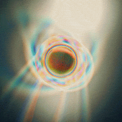 Abstract close-up photo of a circular metallic object with rainbow-colored reflections, with a textured background.