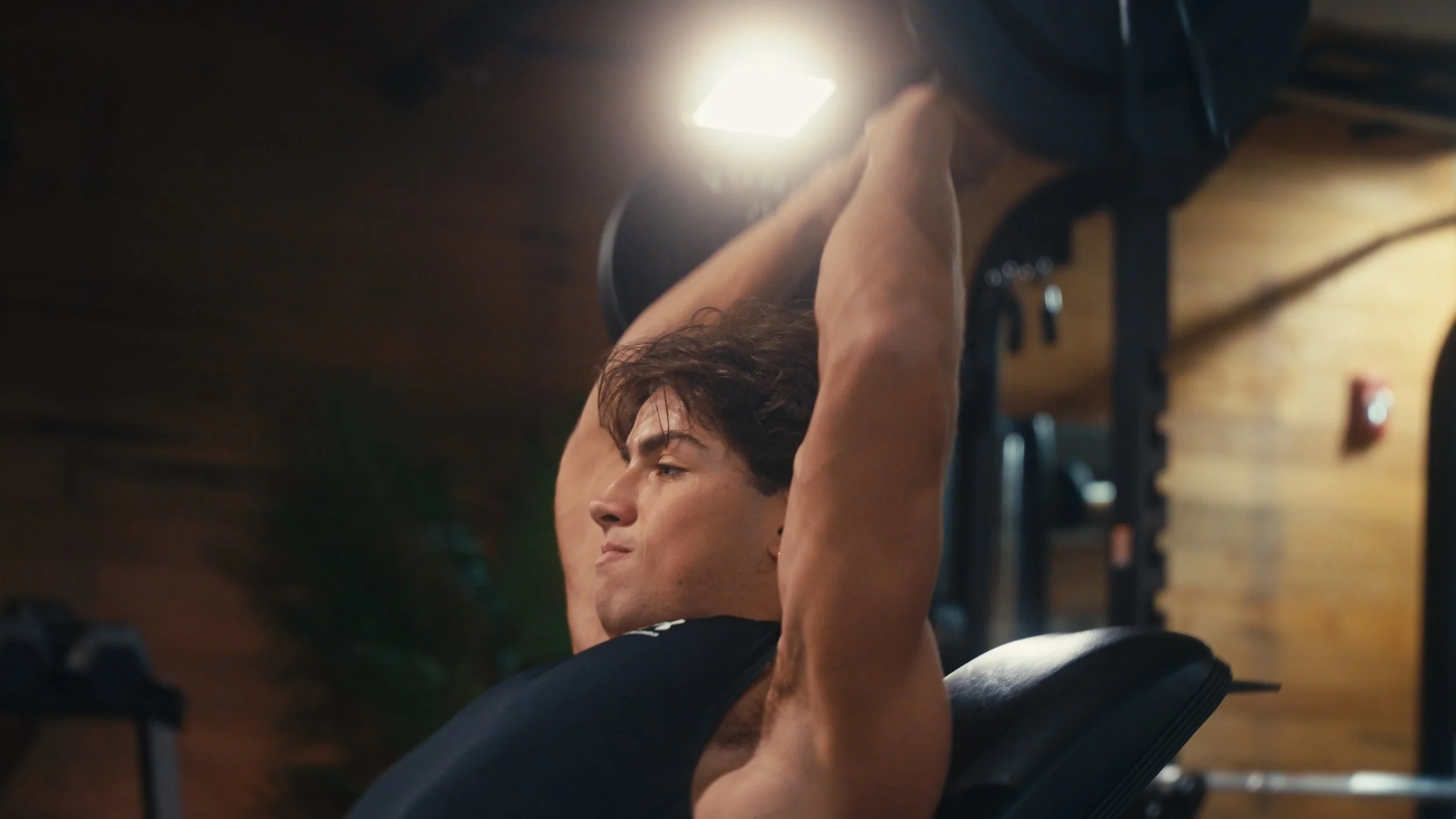 Young man exercising with weights in gym