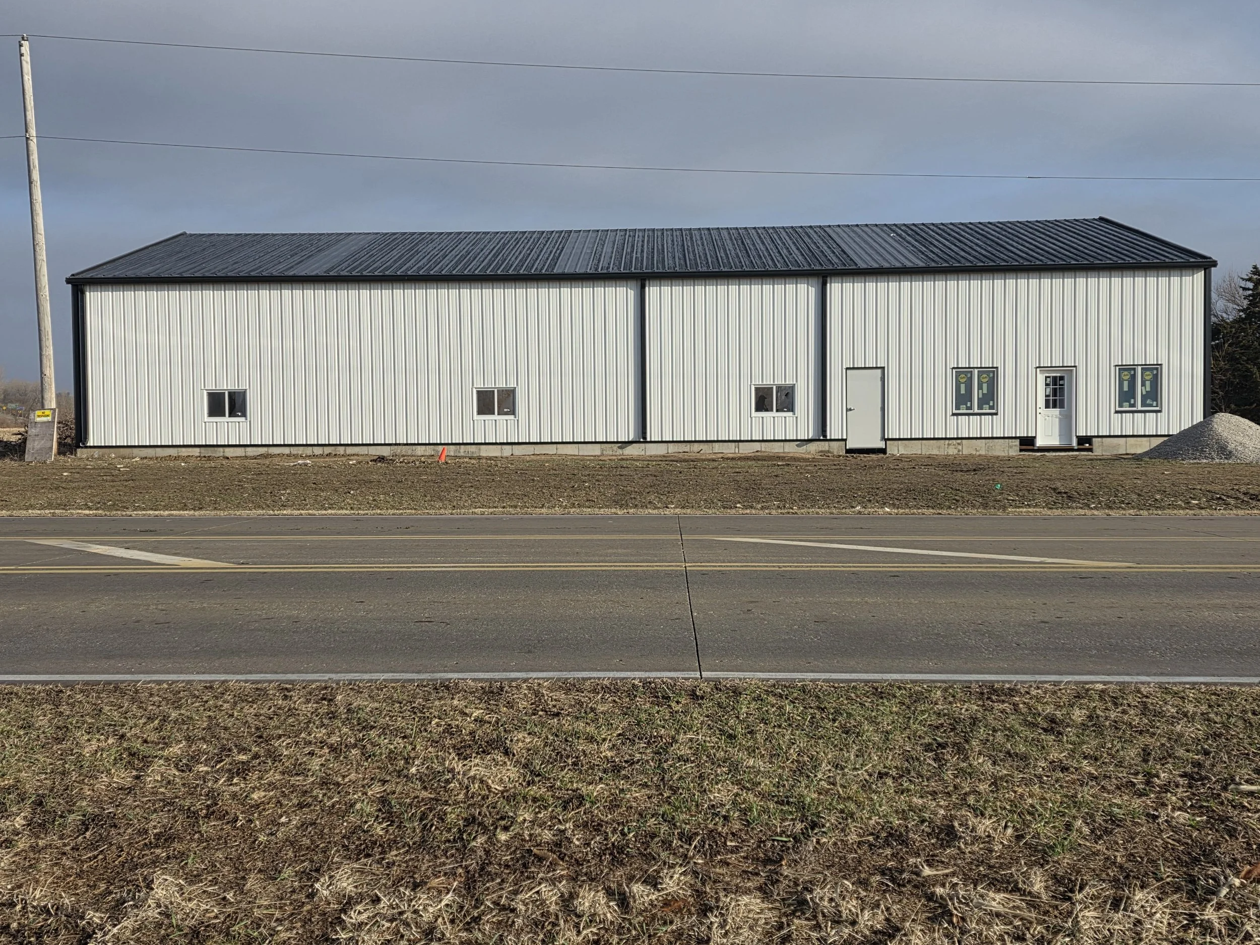 Steel Frame Building exterior with man doors, steel siding, and metal roof