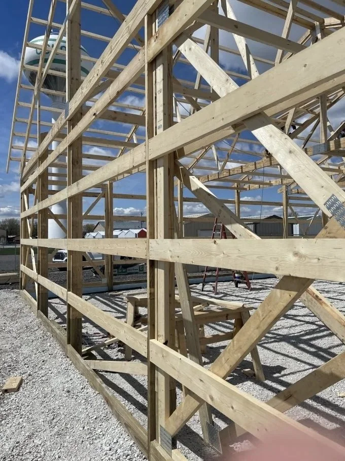 Post-frame wall framing with wood posts and girts installed