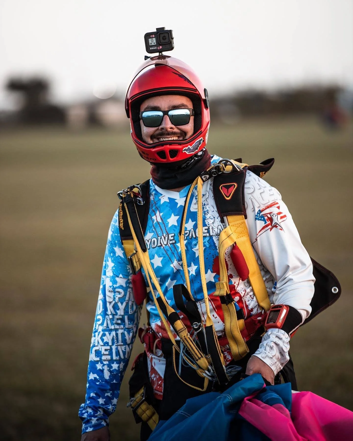 man holds parachute as he walks back to the building smiling