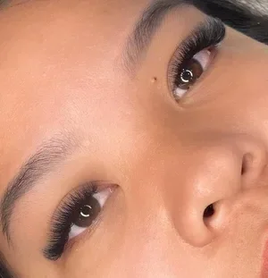 Close-up of a woman's eyes with long, thick eyelashes and well-groomed eyebrows.