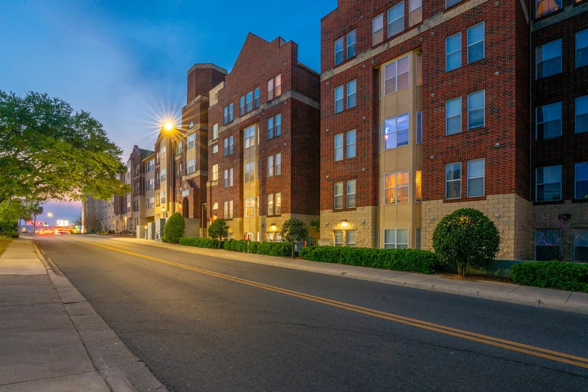 Commercial Real Estate photo of a large apartment complex building at dusk.