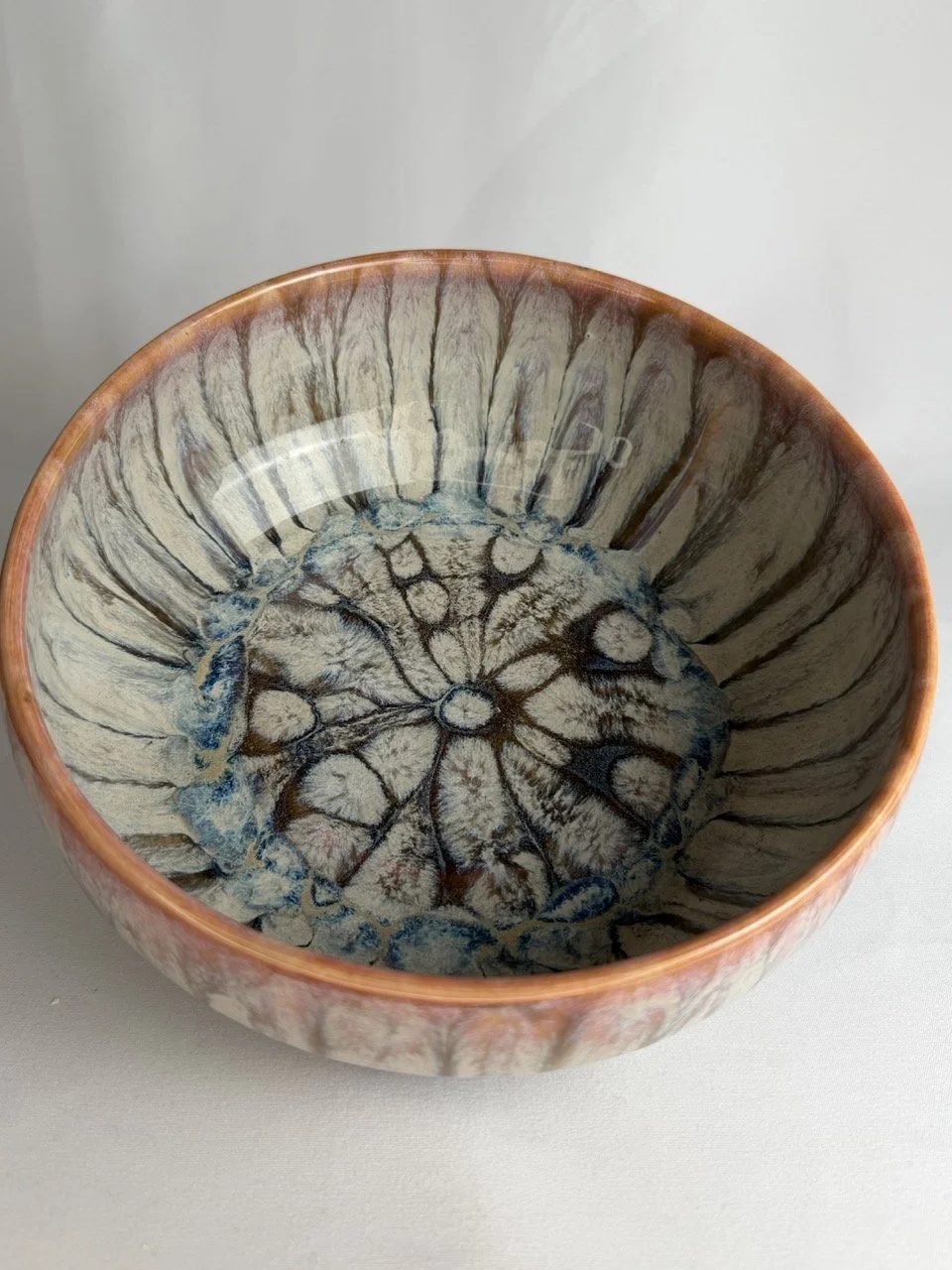 Ceramic bowl with a glossy finish, featuring a marbled and textured interior design with blue, brown, and beige colors.